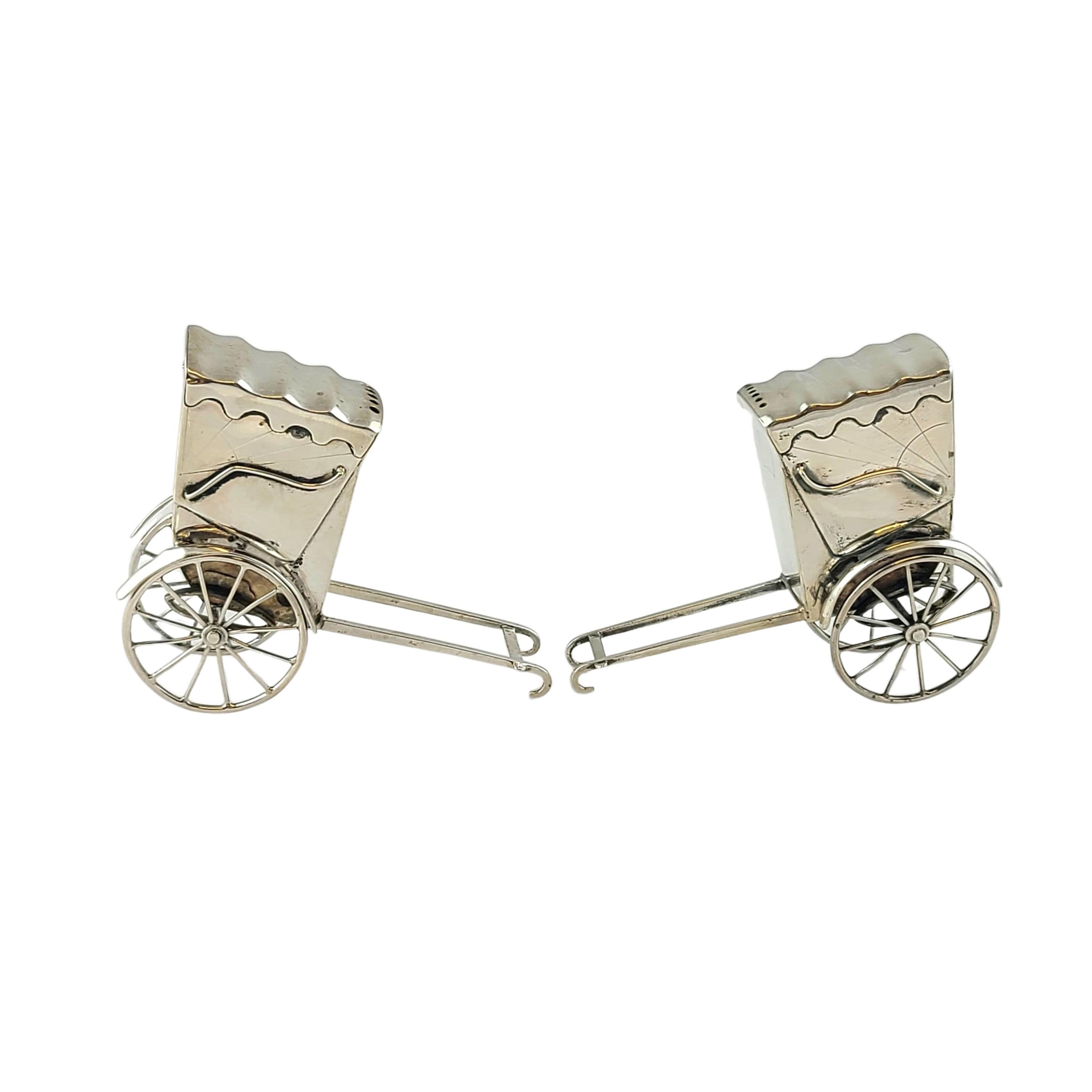 950 sterling silver rickshaw cart salt and pepper shakers from Japan.

Pair of rickshaw shaped salt and pepper shakers with working wheels and an etched sun design. A sliding door to fill with salt and pepper on the back of the cart.

Measures
