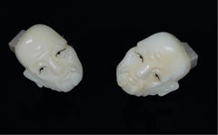 Japanese a pair of finely carved cuff links with opposing faces