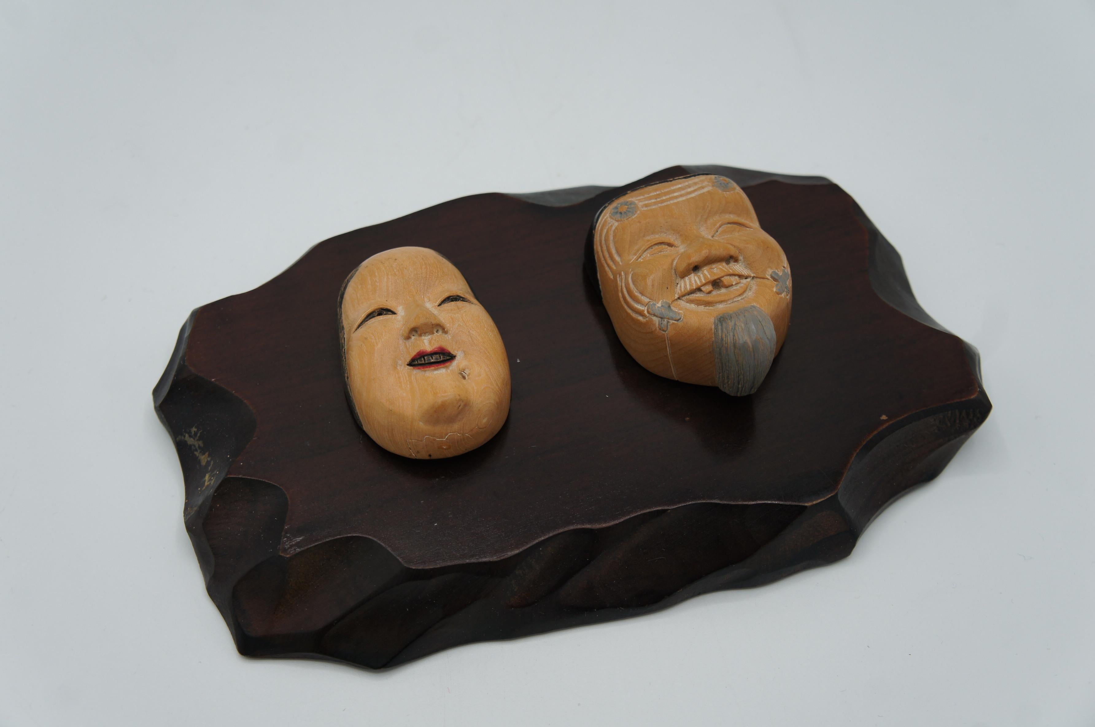 These are wooden netsukes made in Japan around showa period 1980s.
One is called 'Onnamen' and there one is called 'Okinamen'.
These are masks that we use during Noh theater. 

Netsuke is a miniature sculpture, originating in 17th century