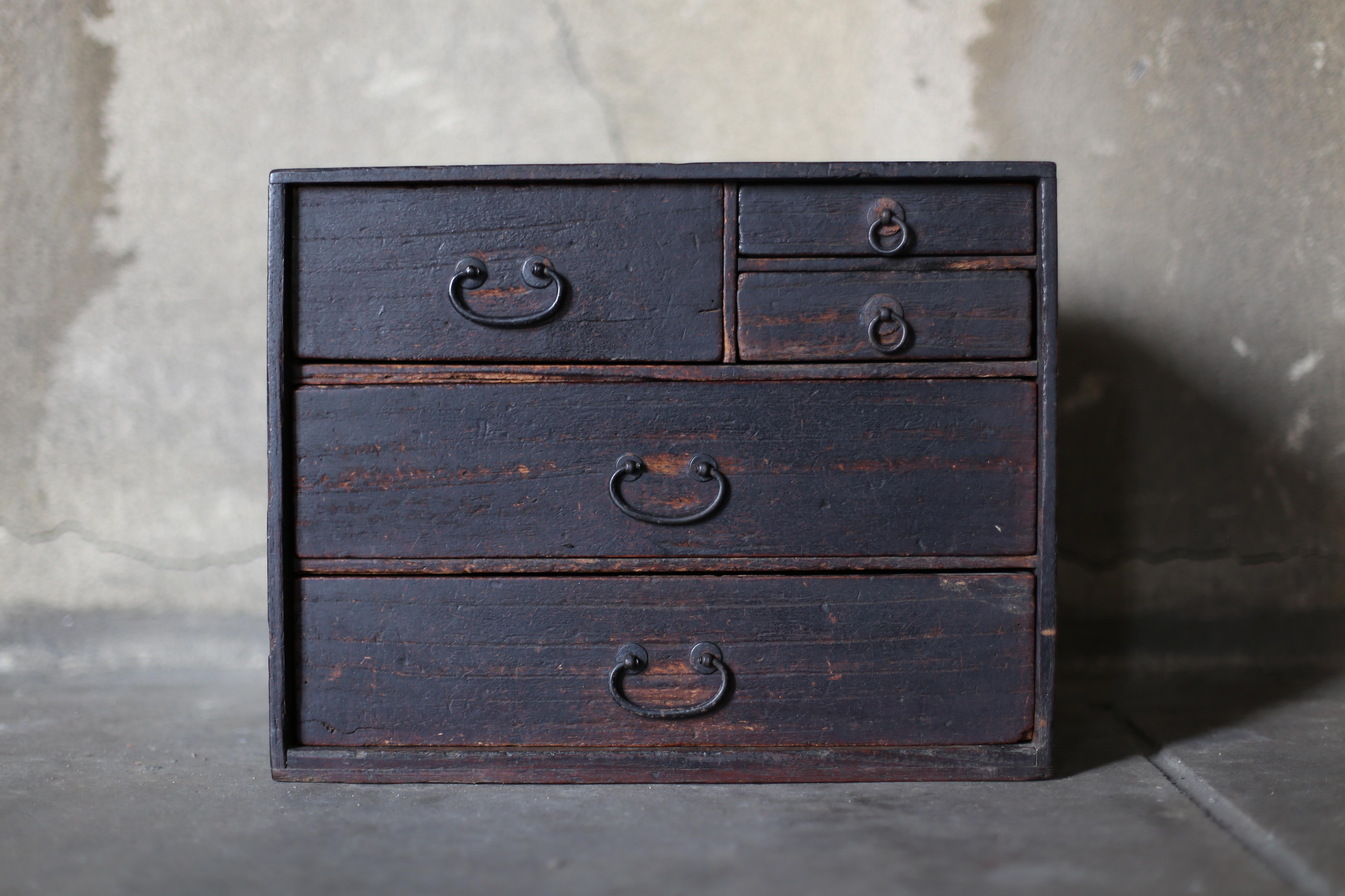 Very old Japanese black drawer storage.
The furniture is from the Meiji period (1860s-1900s).
Material is cedar wood.
The handles are made of iron.

The design is simple and lean.
It is a very beautiful piece of furniture with a uniquely Japanese