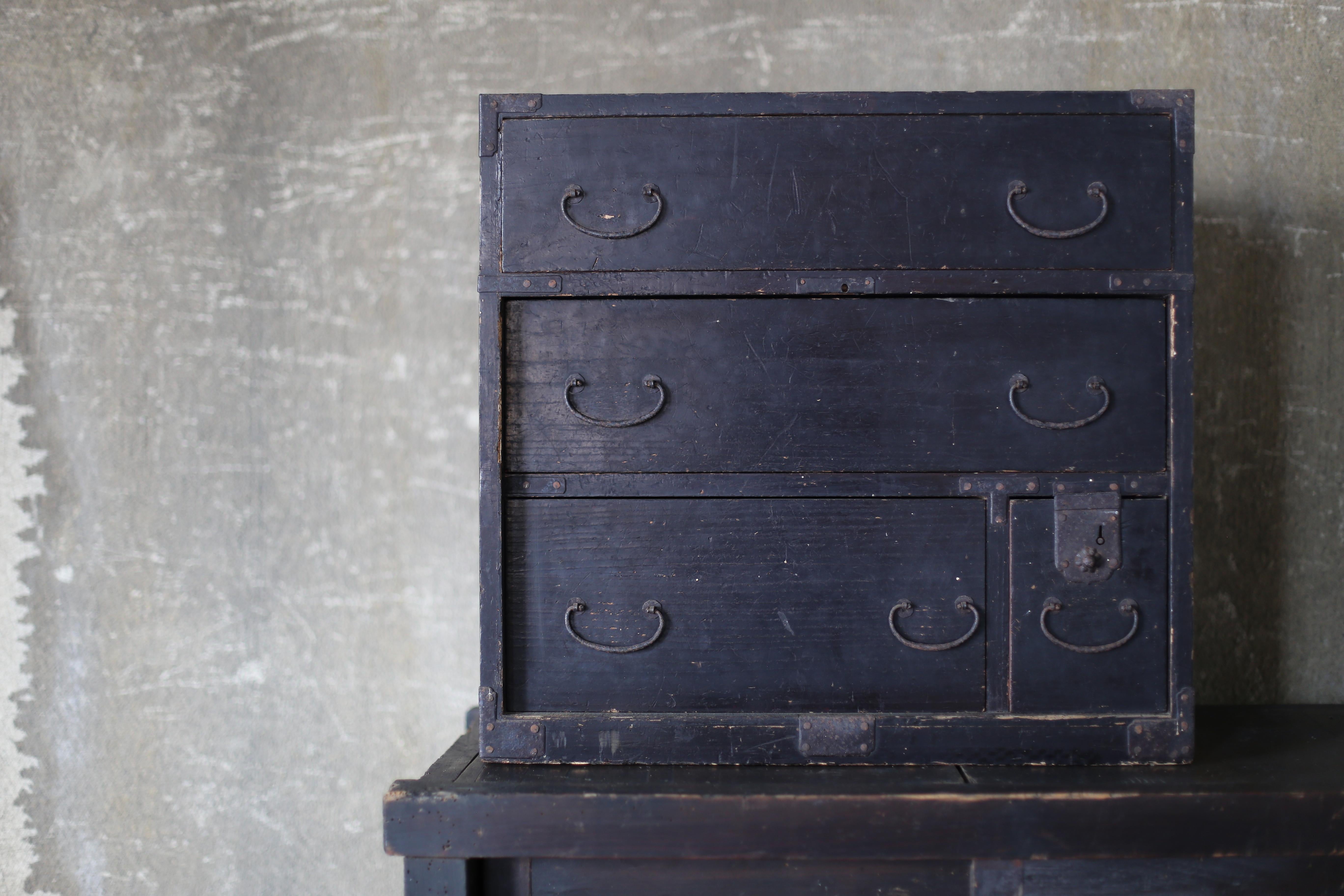This is a very old black-lacquered drawer storage unit made in Japan.
Judging from the delicate handles, this is a very old drawer.
The furniture dates to the Edo period (1603-1868).
The material is cedar.
The handles are made of iron.

The design