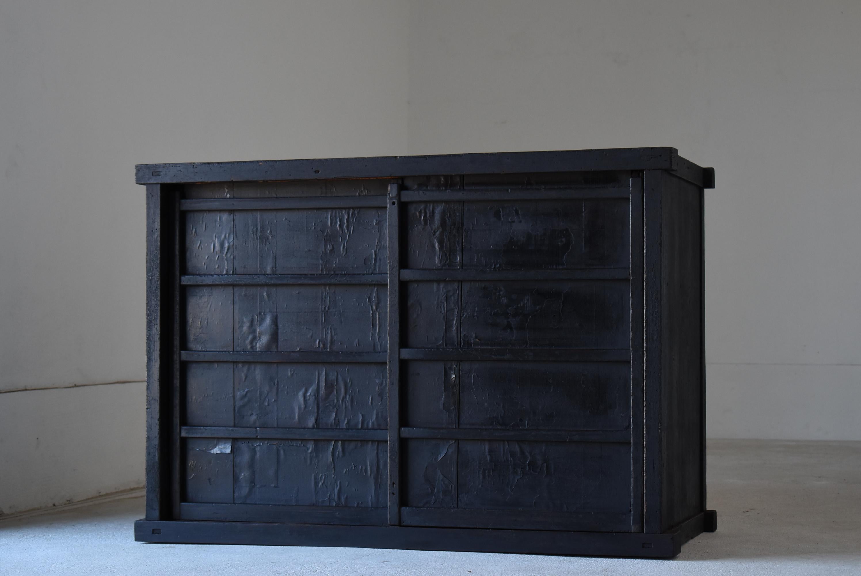 This is a very old Japanese tansu.
It is a piece of furniture from the Edo period. (1800s - 1860s)
It is made of cedar wood.
The doors seem to be covered with paper.
It is very rare.

Black chests like this one are not seen in Japan every