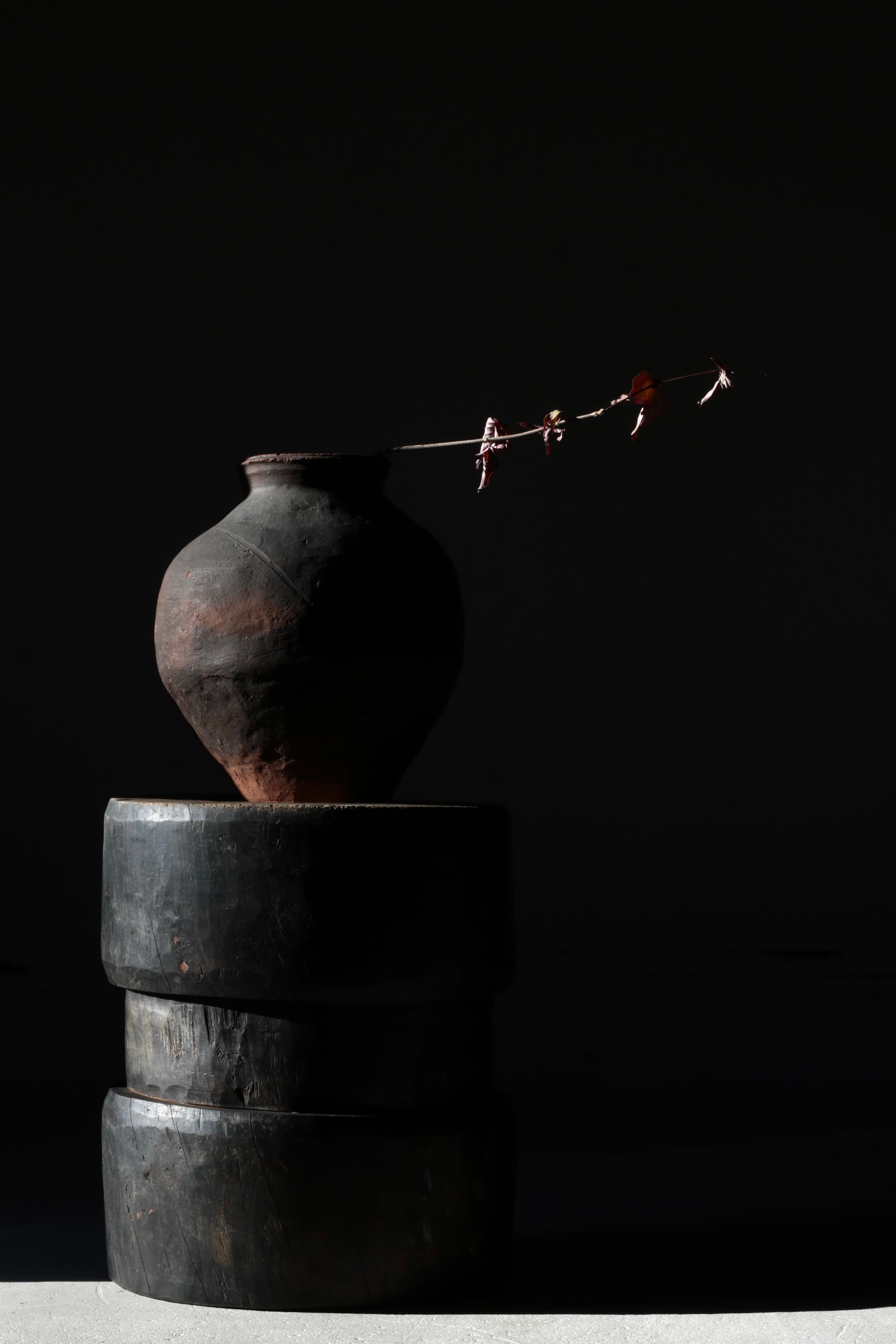 Cette table basse est fabriquée à partir d'un vieux mortier japonais.

Elle est fabriquée en bois de zelkova et daterait de la période Meiji.

L'harmonieuse couleur noire, qui s'est naturellement modifiée au fil du temps, est saisissante.