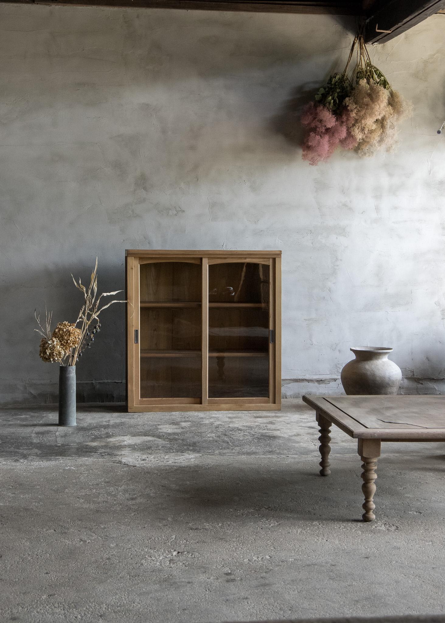 Dieser antike japanische Schrank wurde in der frühen Showa-Periode (1926-) hergestellt.

Das aus Hinoki-Holz (japanische Zypresse) gefertigte Stück hat im Laufe der Zeit eine weiche, gealterte Patina entwickelt, die seinem Aussehen Wärme und Tiefe