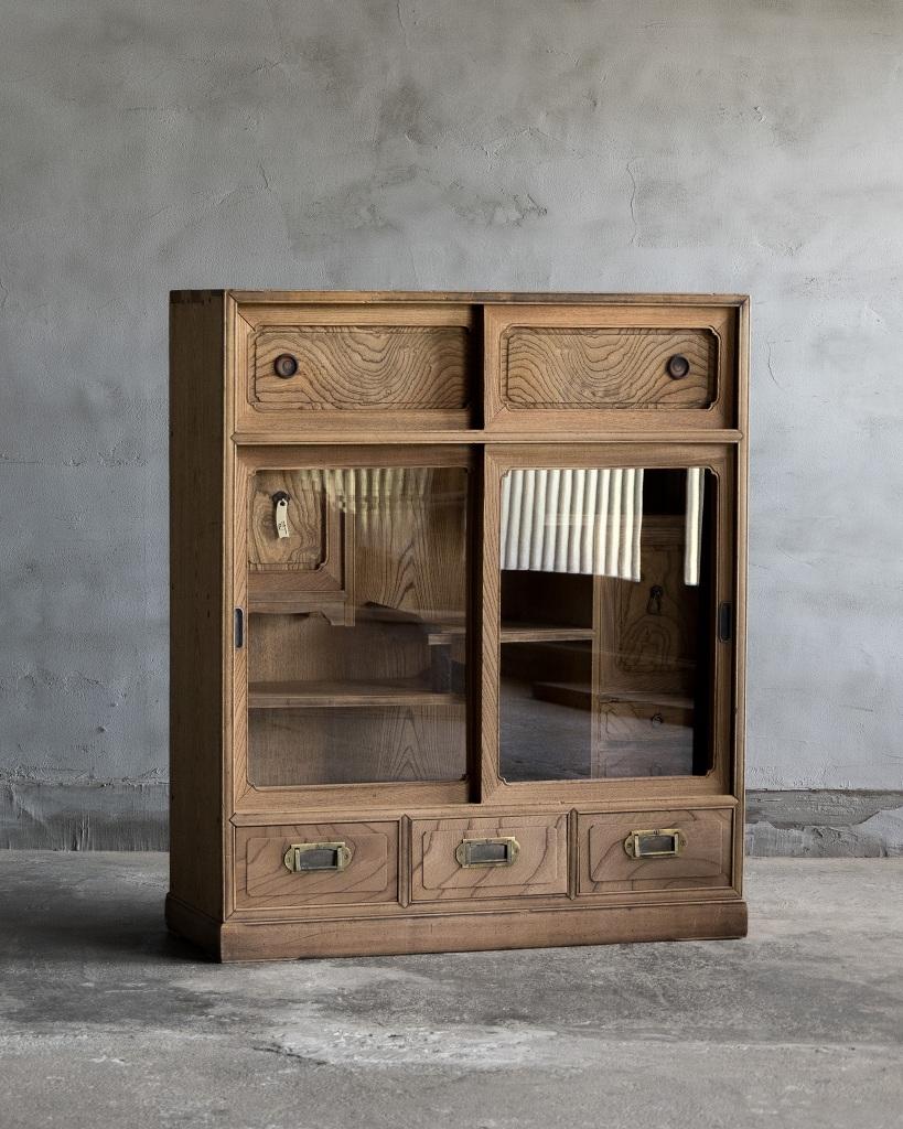 This cabinet was crafted in the Taisho Era'1912-1926'.

This antique piece features a harmonious blend of materials, with Zelkova wood used on all sides and the front edge framed in persimmon wood, highlighting its quality craftsmanship. The handles