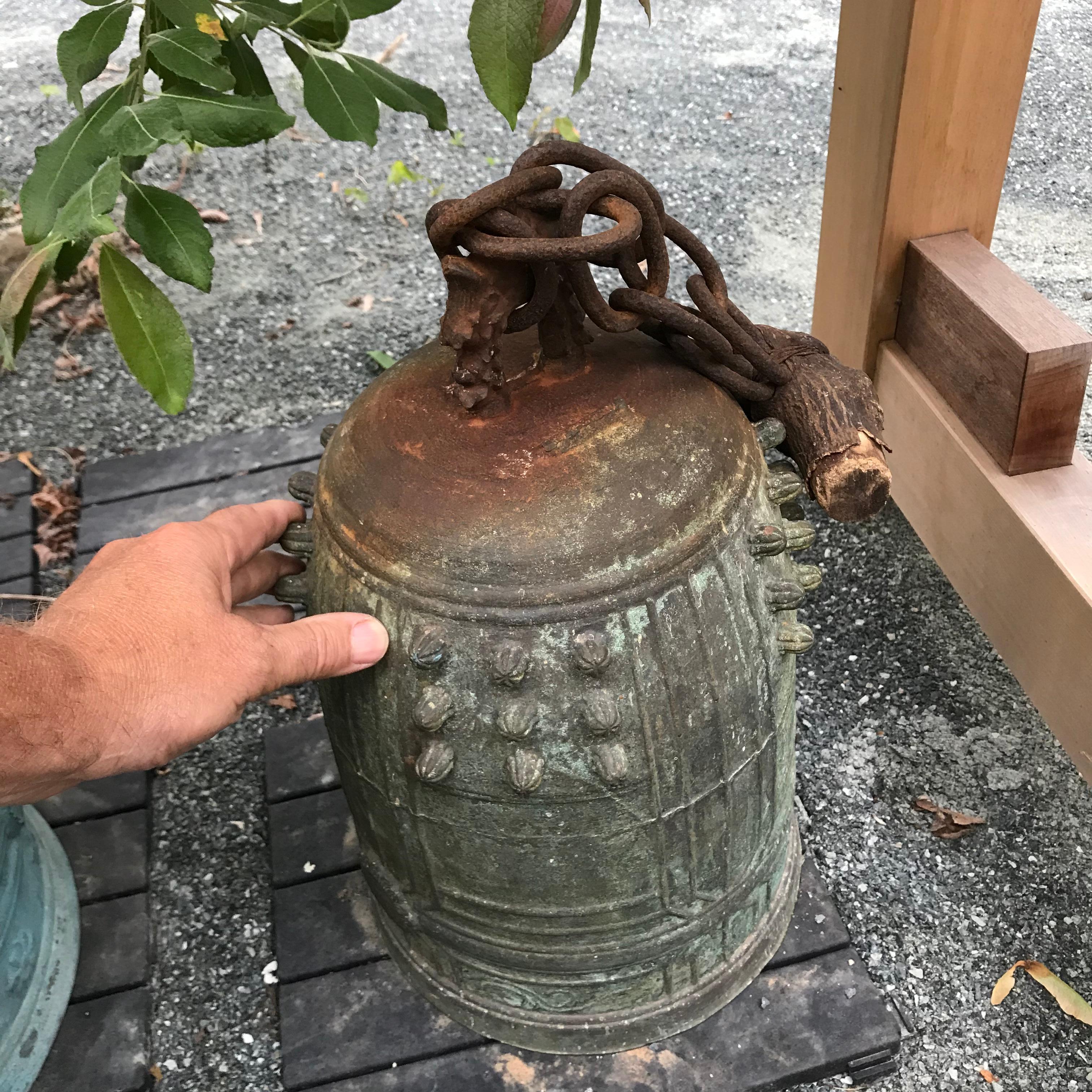 An unusual and unique find from Japan.

This is no ordinary antique bronze bell.

While cast in solid bronze, this one retains its original hand-wrought iron chain and yes, an original wooden limb piece at the end of the chain from where it had