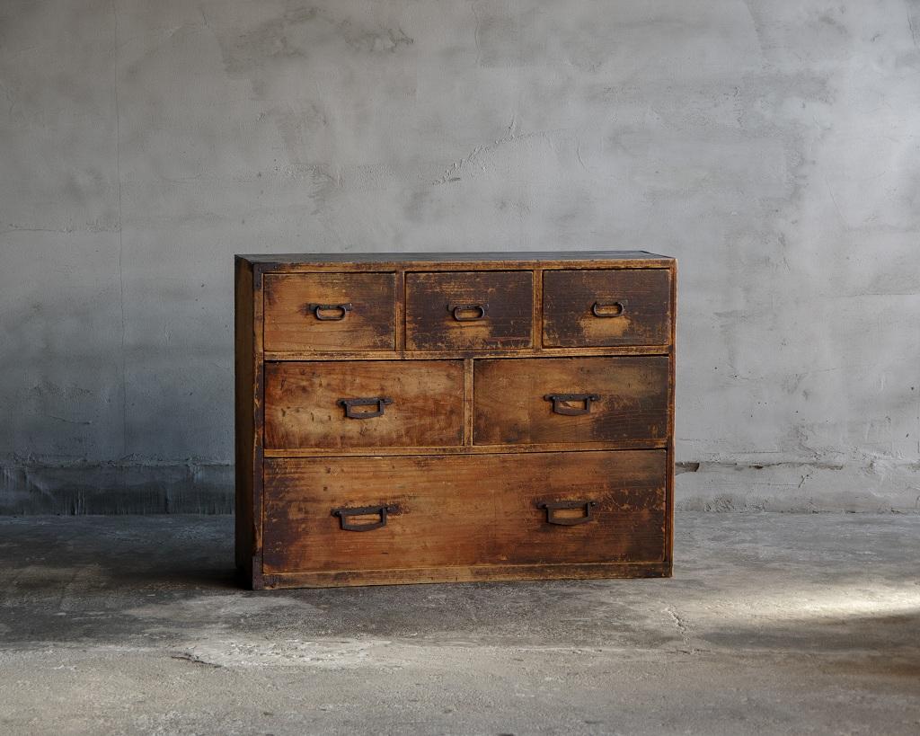 Il s'agit d'une commode japonaise fabriquée pendant l'ère Meiji (1868-1912).

Doté d'un design élancé, il offre un rangement pratique grâce à ses six tiroirs.
Le bois présente des zones où la finition s'est usée, révélant son grain naturel, tandis