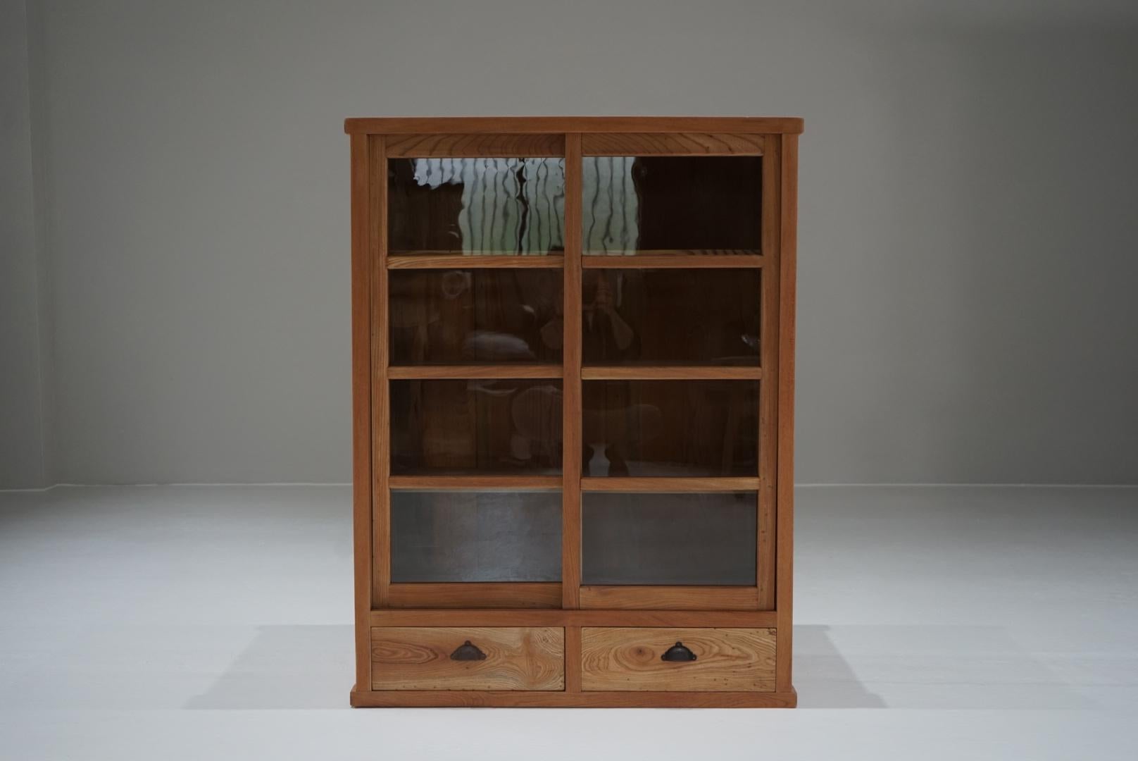 This is an old Japanese glass sliding door storage shelf.
The front is made of zelkova wood and the rest is made of cedar wood.
The shelves are fixed and sturdy, so I think they are suitable for storing tableware, etc.
The sliding door, divided into