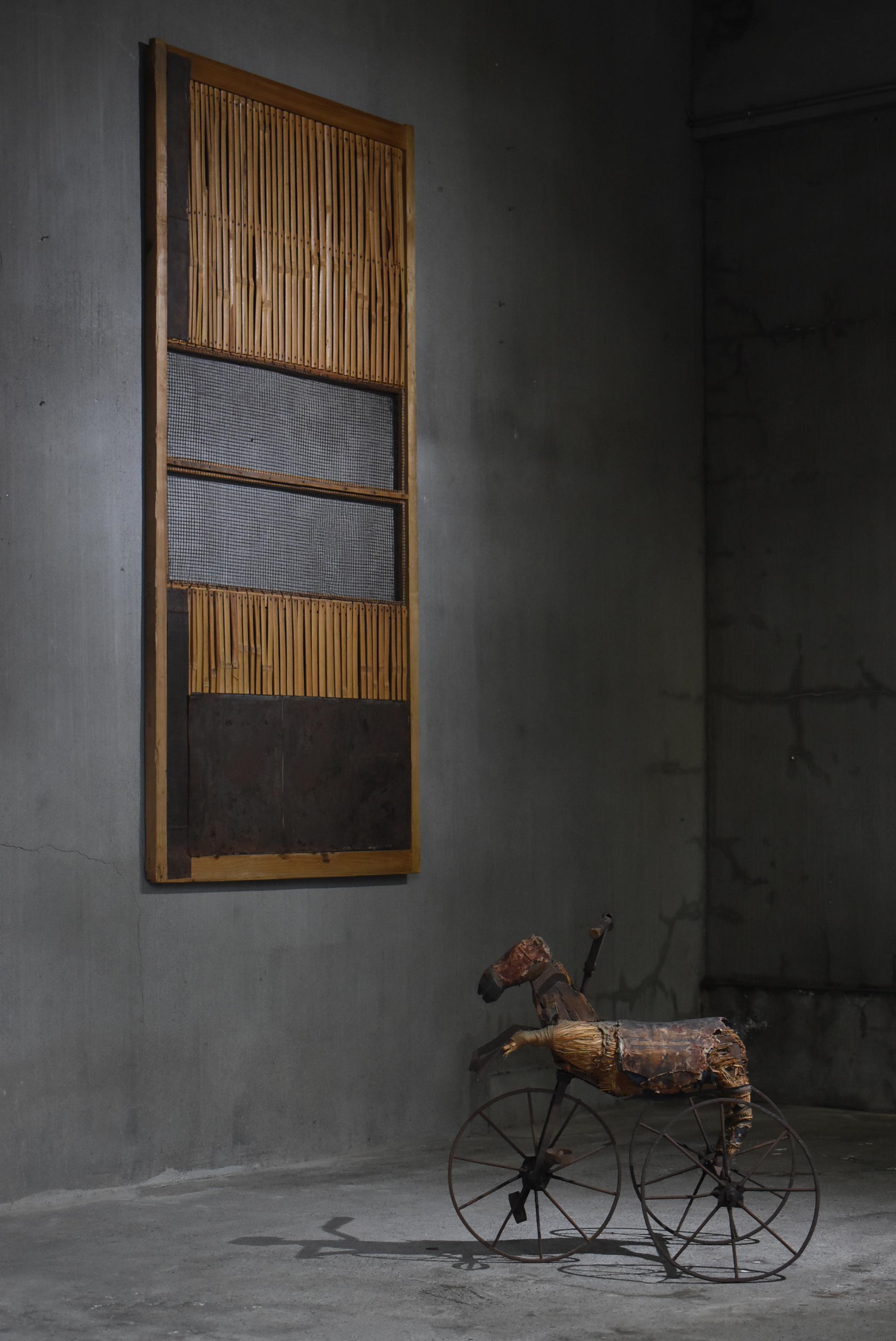 This is a very old sliding door made in Japan.
It is from the Meiji period (1860s-1920s).
It is mainly made of cedar wood and bamboo, and reinforced with tin.
This composition is very unique and looks like an abstract painting.
You can actually use
