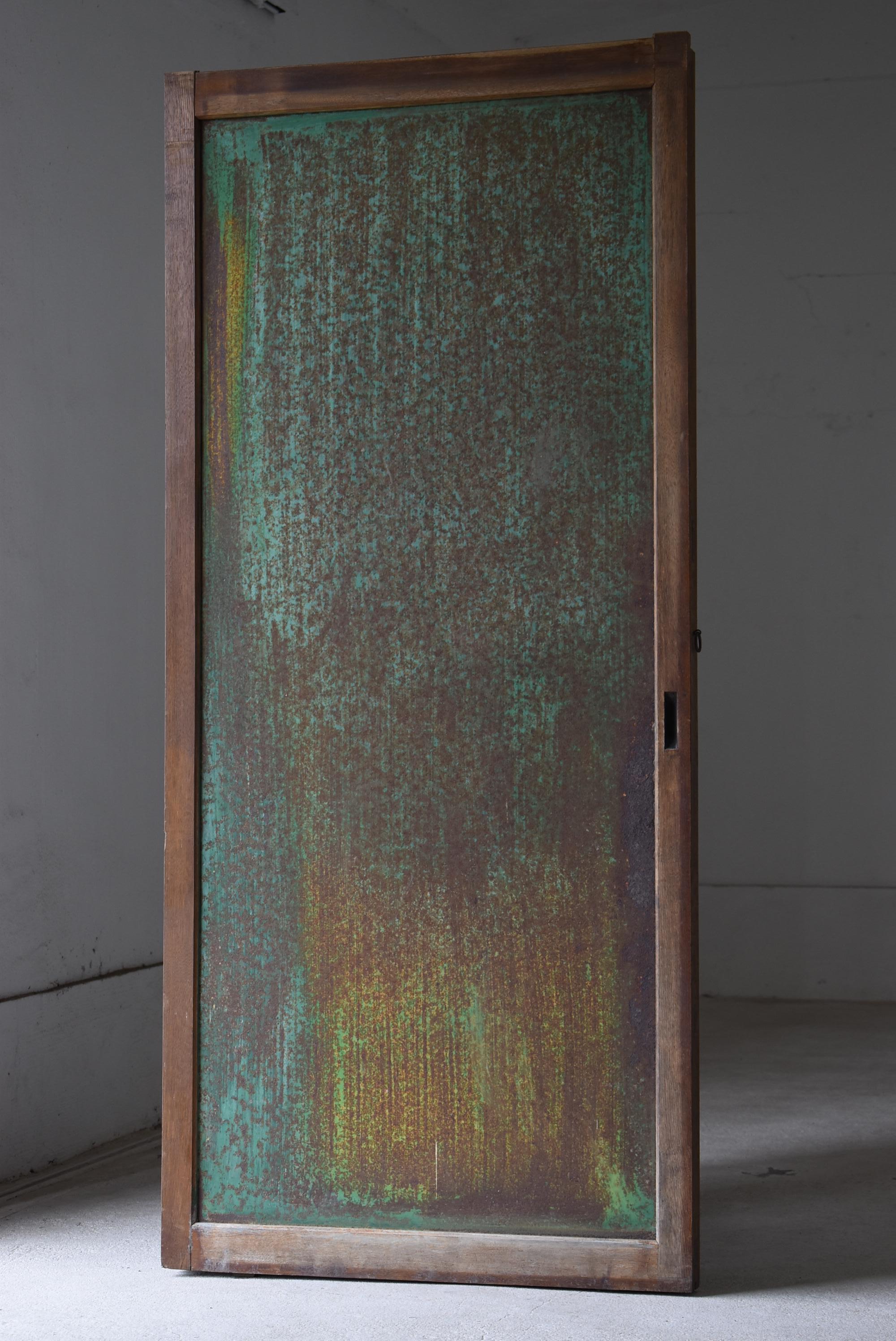 Se trata de una puerta corredera muy antigua fabricada en Japón.
Esta puerta es de principios del periodo Showa (1900-1940).
El armazón es de madera de castaño, la superficie es de chapa de hierro y la parte posterior está cubierta de yeso.

Ambas