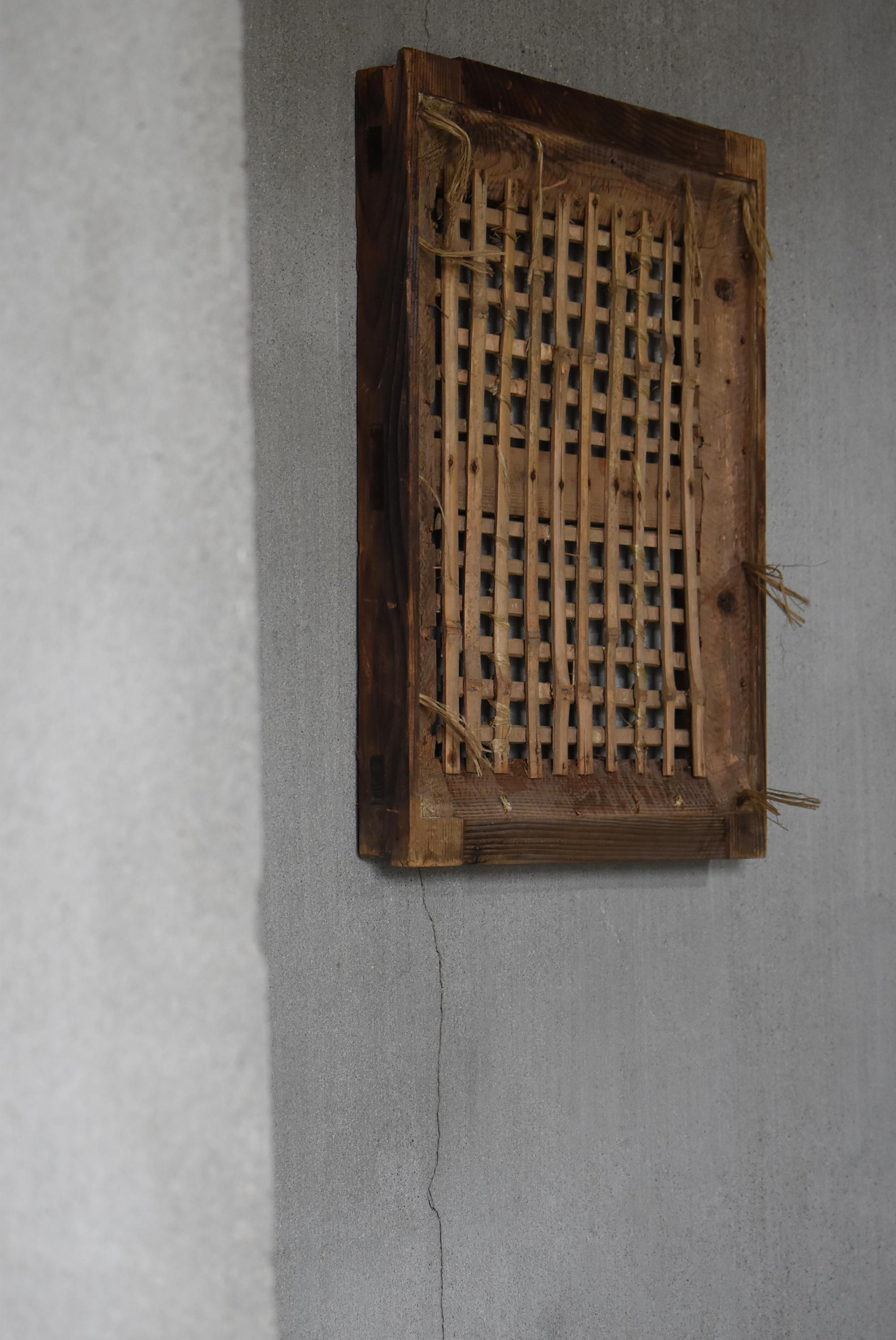 This was a very old Japanese warehouse (kura) window sliding door.
It was made during the Meiji period (1860s-1900s).
The frame is made of cedar wood and the lattice is bamboo.

It was plastered at the time.
However, over time, the plaster has