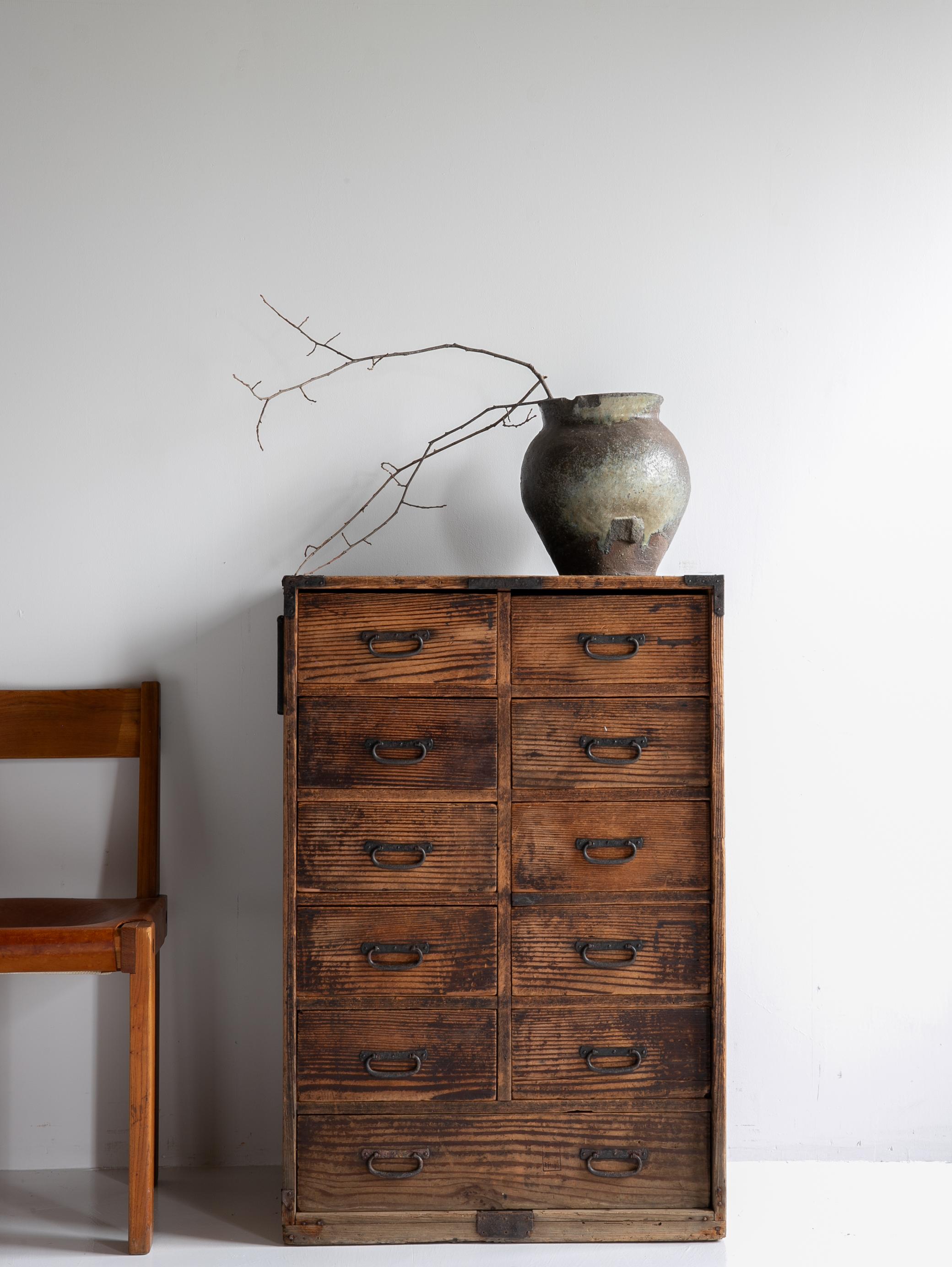 This is a very old drawer storage chest made in Japan.
It dates back to the Meiji era (1860s–1920s) and is crafted from Japanese cedar wood.
The metal fittings are made of iron.

The design is simple and efficient, free of excess.
It embodies a