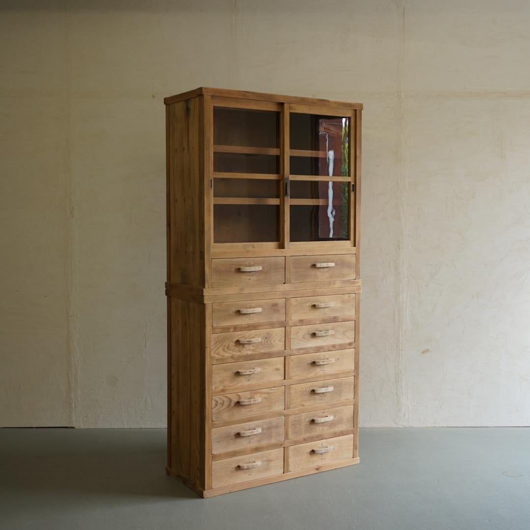 This is an old Japanese glass cabinet.
The frame is all made of solid cedar wood.
It has 14 drawers, and it looks like a picture just by storing it there, but it is also a practical storage shelf that can store things you want to show and things you