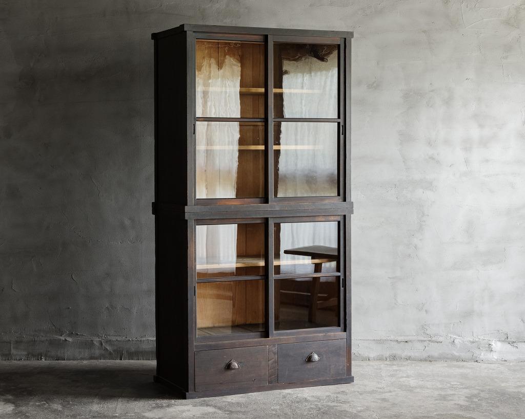 This antique cupboard was crafted in the Late Meiji Era(1868-1912).

Crafted in an aged black finish, this cabinet exudes a sense of timeless elegance, perfect for adding character to any space. The antique glass sliding doors sway gracefully,