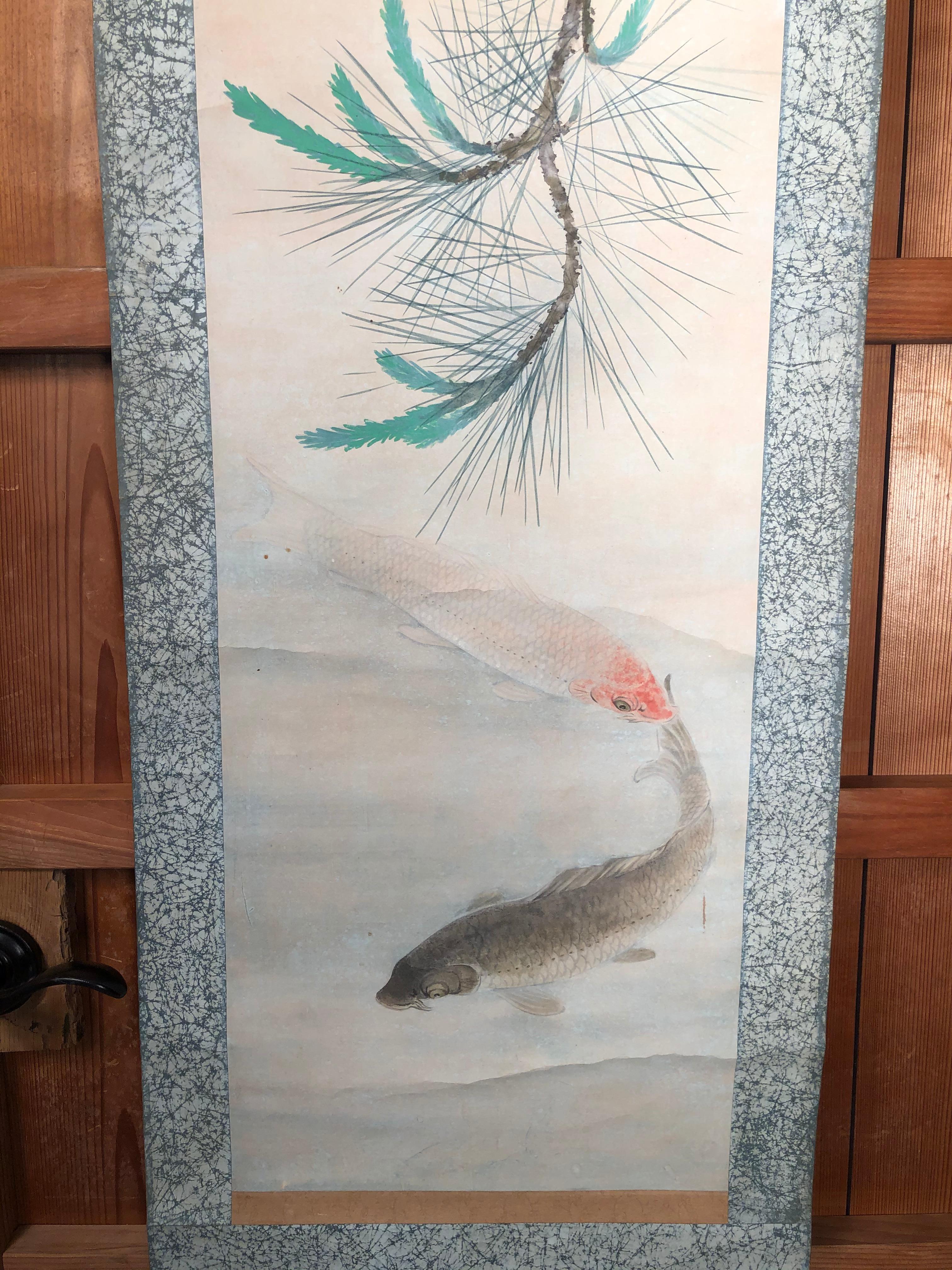 Japan, a light and lively colored family of Koi or Carp ripple the waters in this auspicious art composition hand painted and signed scroll dating to the early Taisho era, early 20th century. Koi soothe the mind and spirits and reminds us of their