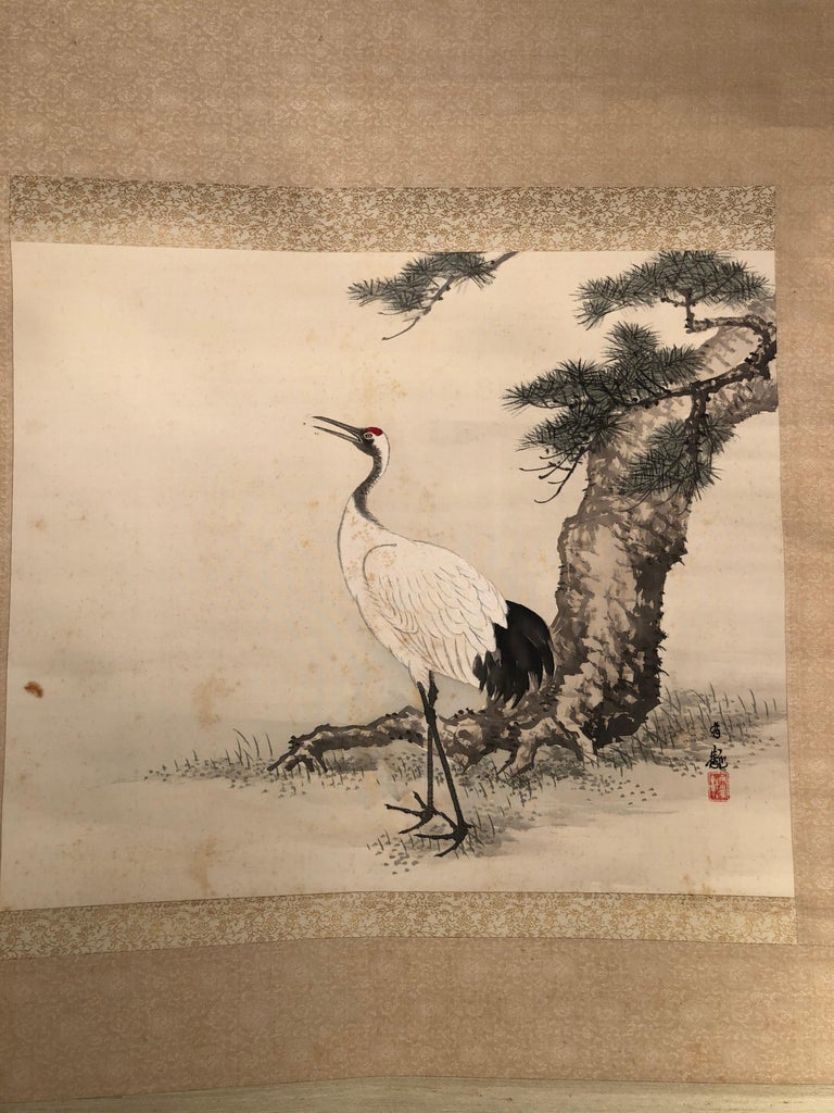A beautiful antique free hand rendition of a Japanese hand painted scroll of a Red Headed Crane with pine trees accompanied by its important signed wooden box tomobako, - this 120 year old scroll worthy of your favorite room and serious