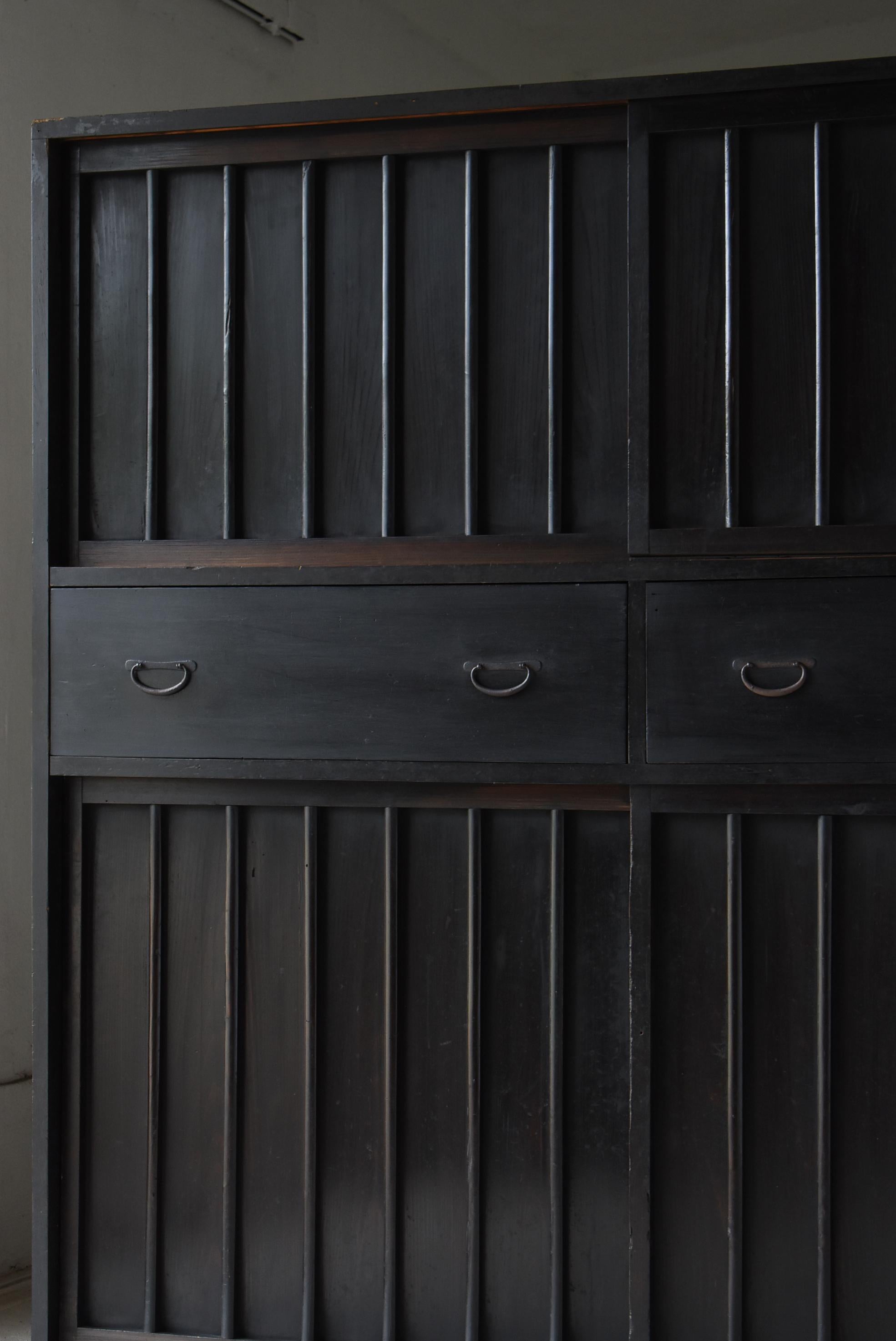 Se trata de un enorme Tansu negro muy antiguo fabricado en Japón.
Este mueble se fabricó en la era Meiji (décadas de 1860 a 1900).
El material es madera de cedro.

El diseño es sencillo y rústico.
Ningún diseño inútil, máxima simplicidad.
Puedes