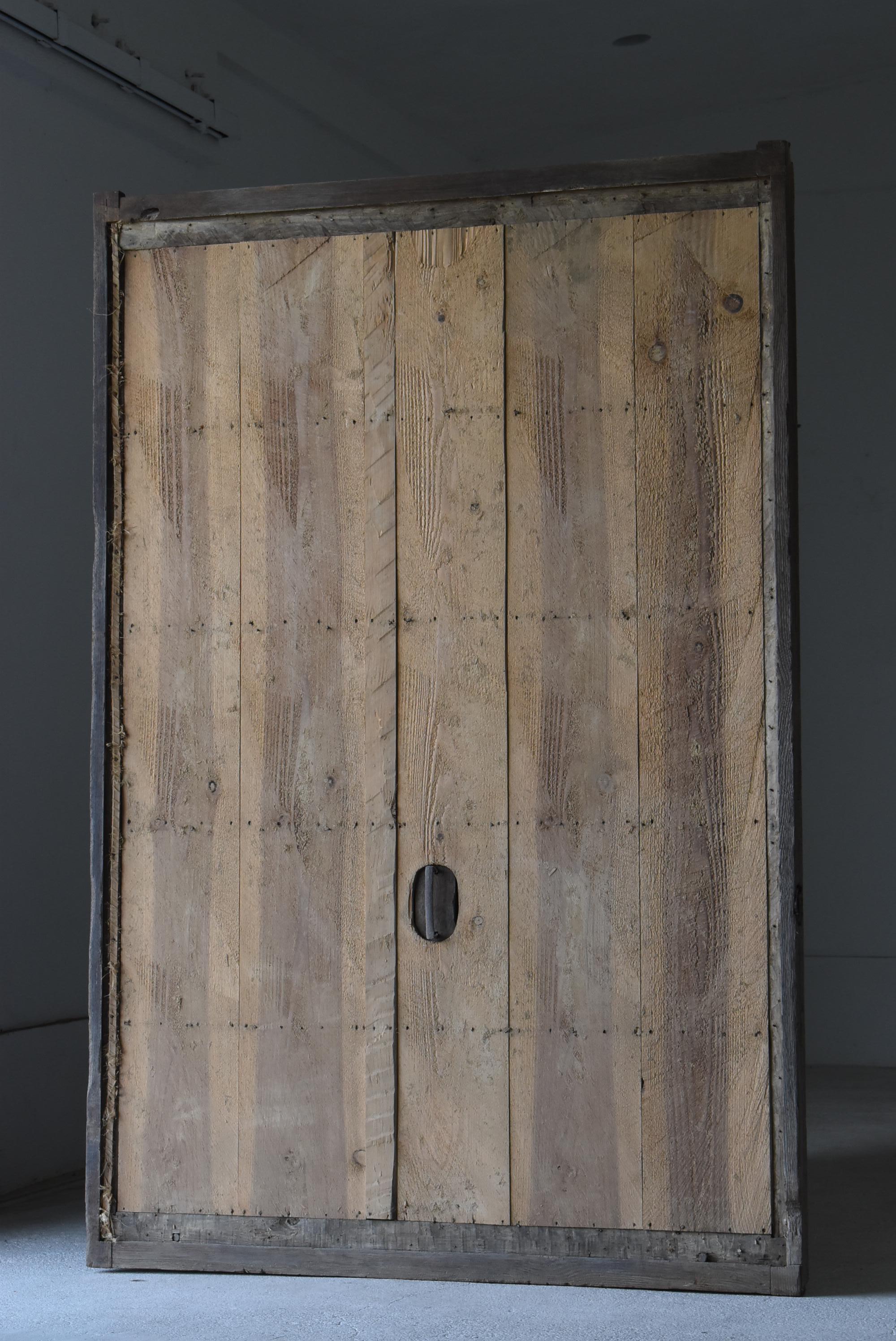 This is a huge door of a very old warehouse in Japan.
This door is from the Meiji era. (1860s-1900s).
It is mainly made of cedar wood with iron handles.

The door was made of plaster, but the plaster peeled off to reveal this appearance.
It is as