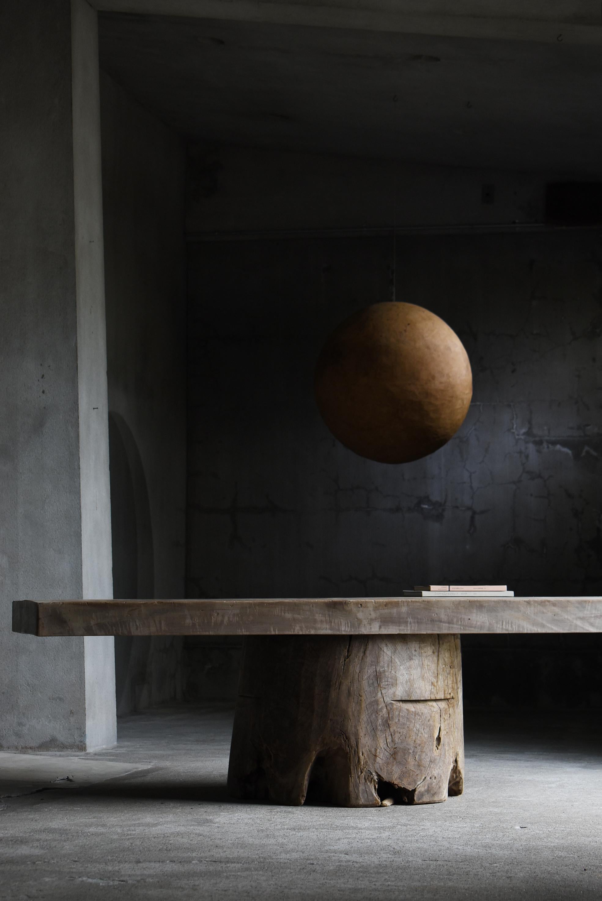 Dies ist ein monumentaler japanischer Vintage-Tisch aus kostbarem Holz aus der Meiji- bis Taishō-Periode (1860er-1920er Jahre), der eine zeitlose Würde ausstrahlt. Das markante Design besteht aus einer massiven, 100 mm dicken Platte, die kühn auf