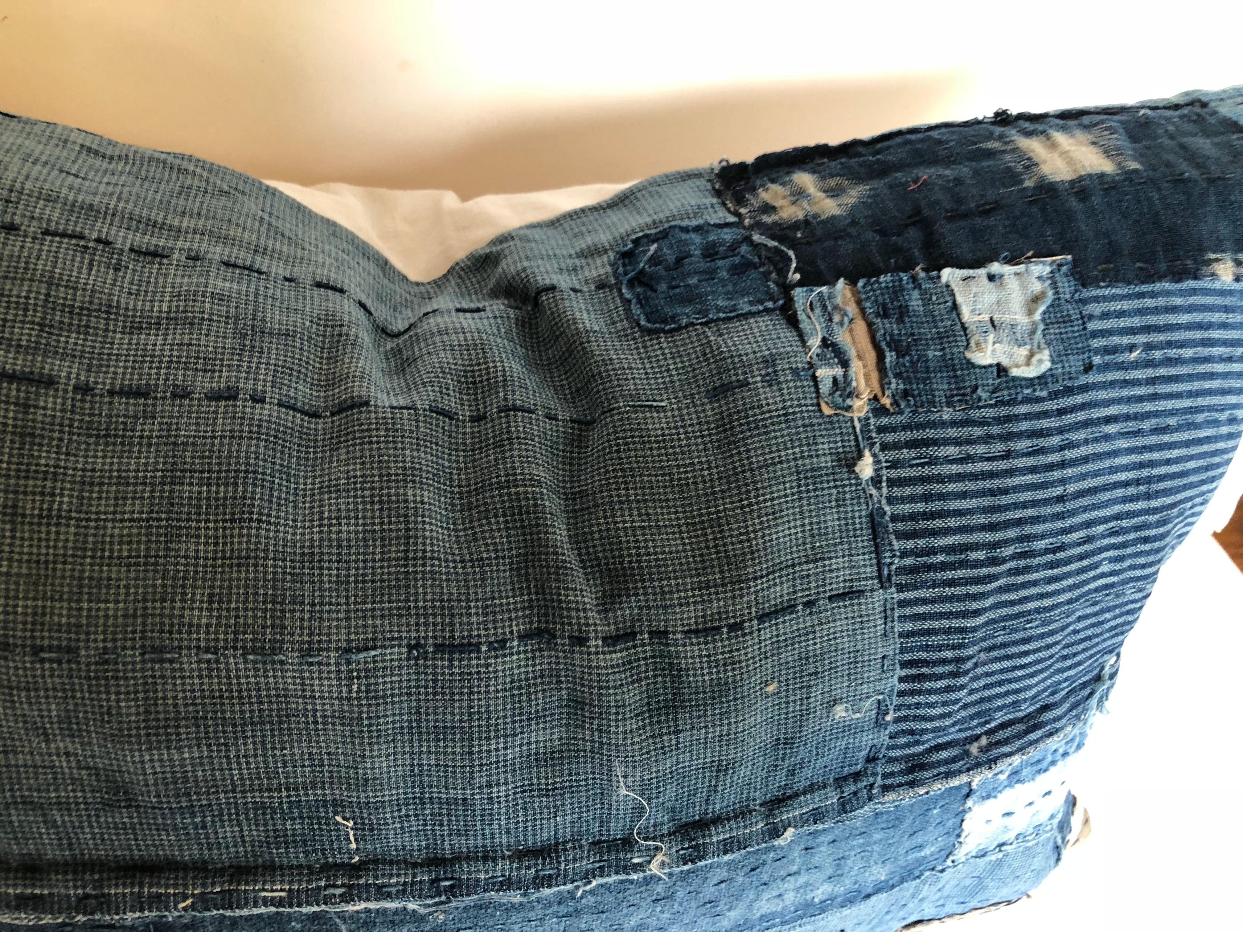 Custom pillow cut from an antique Japanese indigo boro futon cover. Every scrap of hand loomed cotton indigo was saved for the boro clothing and futon covers, patched together with sashiko stitching. The rare antique boros are now valued pieces of
