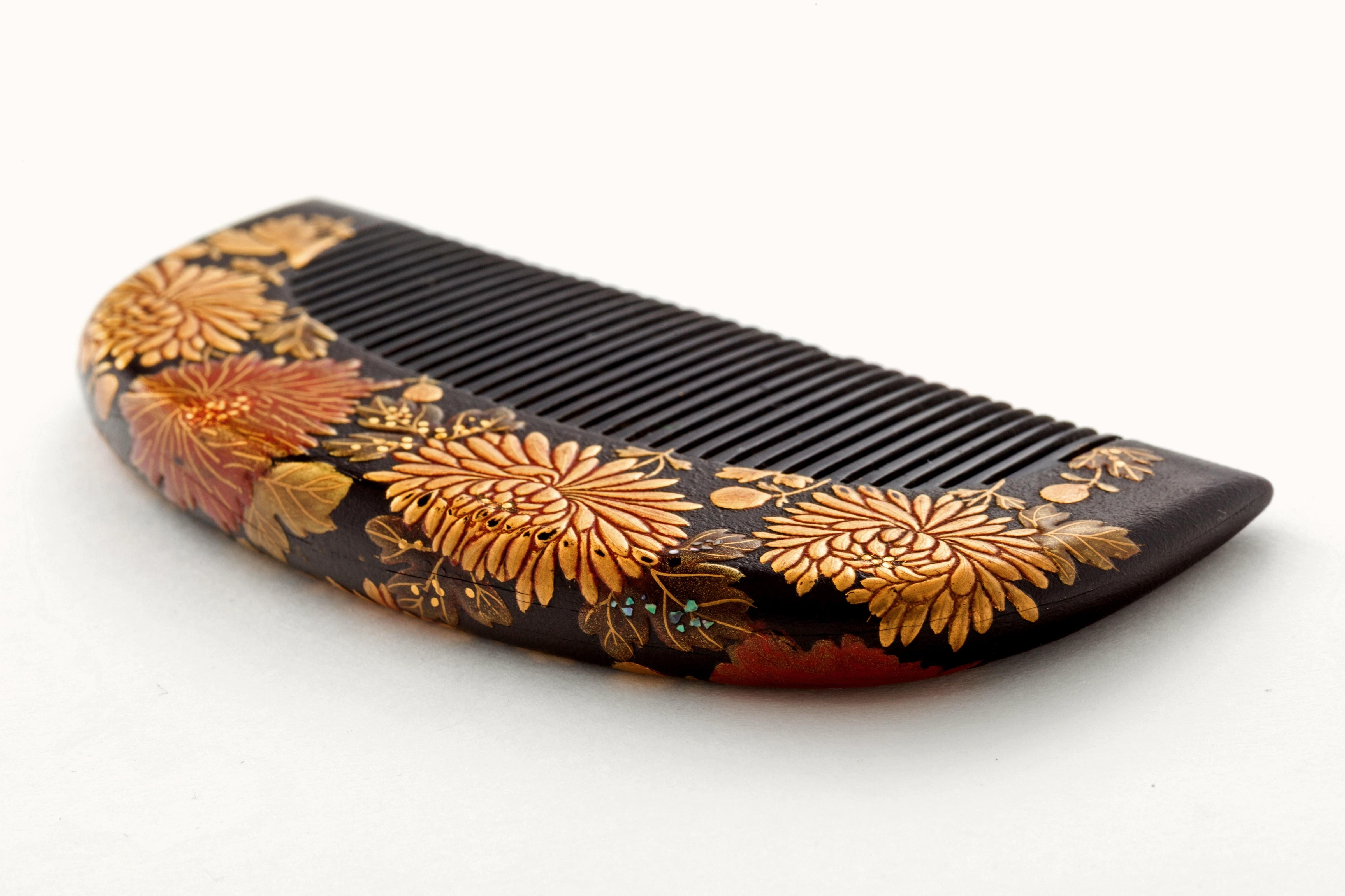 Atemberaubender antiker japanischer Lackhaarkamm mit einem geometrischen, blütenblattartigen Hintergrund aus stilisierten Chrysanthemen und Blumen in Gold und rotem Maki-e. Möglicherweise aus der Edo- oder Meiji-Zeit. Aus dem Nachlass eines