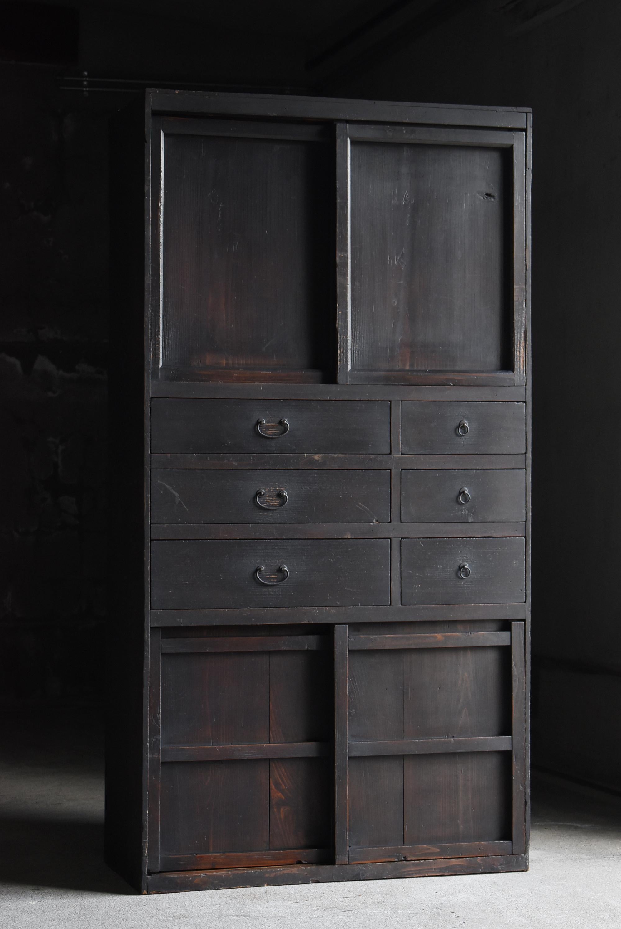 Se trata de un gran Tansu negro fabricado en Japón.
Se fabricó en el periodo Meiji (1860-1900) y es de madera de cedro con asas de hierro.
Por lo general, en muchos casos se observa el Tansu horizontal, pero éste es un tipo muy raro que se extiende