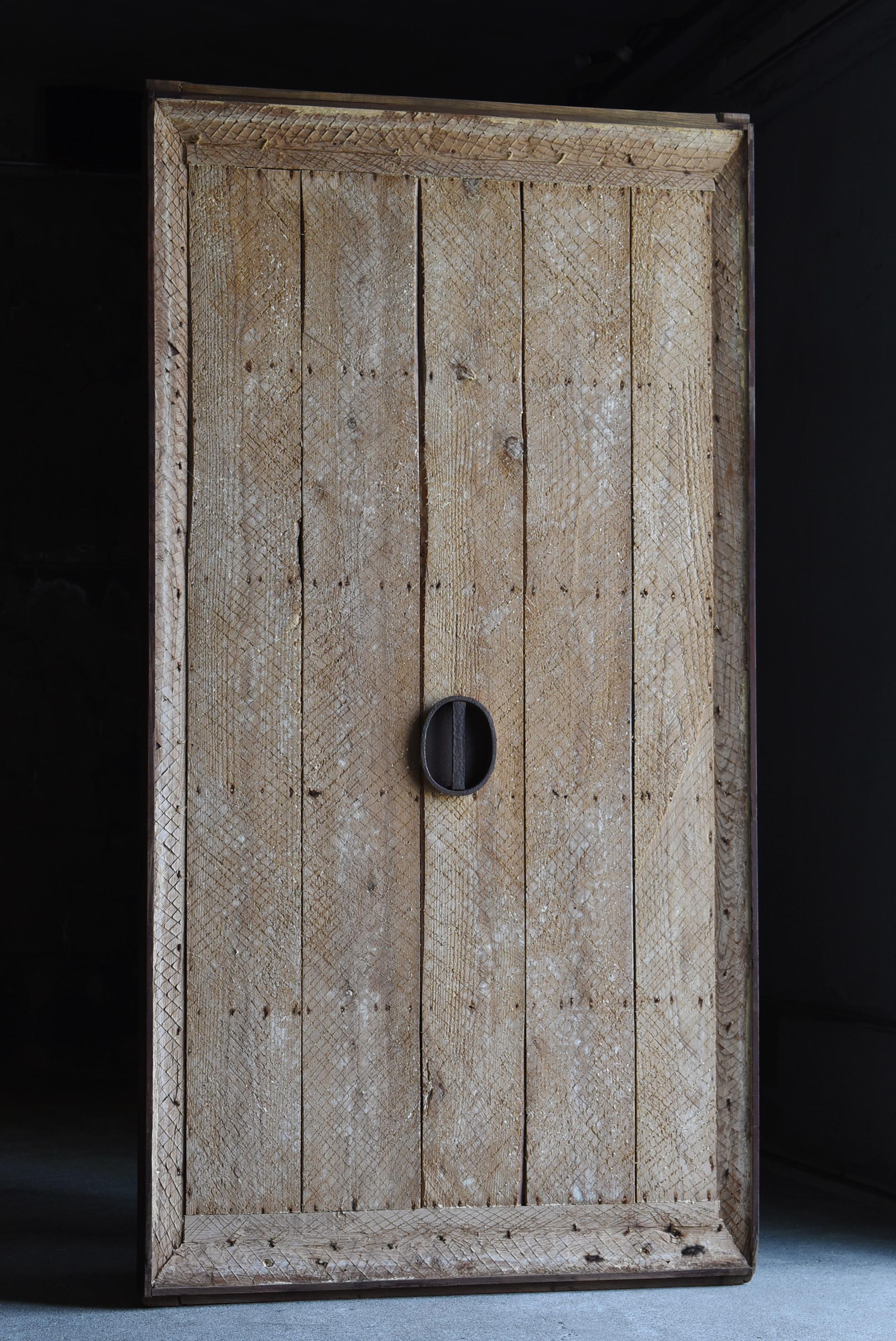This is a large sliding door from a very old Japanese warehouse.
This door was made in the Meiji Era. (1860s-1900s).
It is made of zelkova and cedar wood with iron handles.

It was plastered at the time, but the plaster has peeled off, exposing the