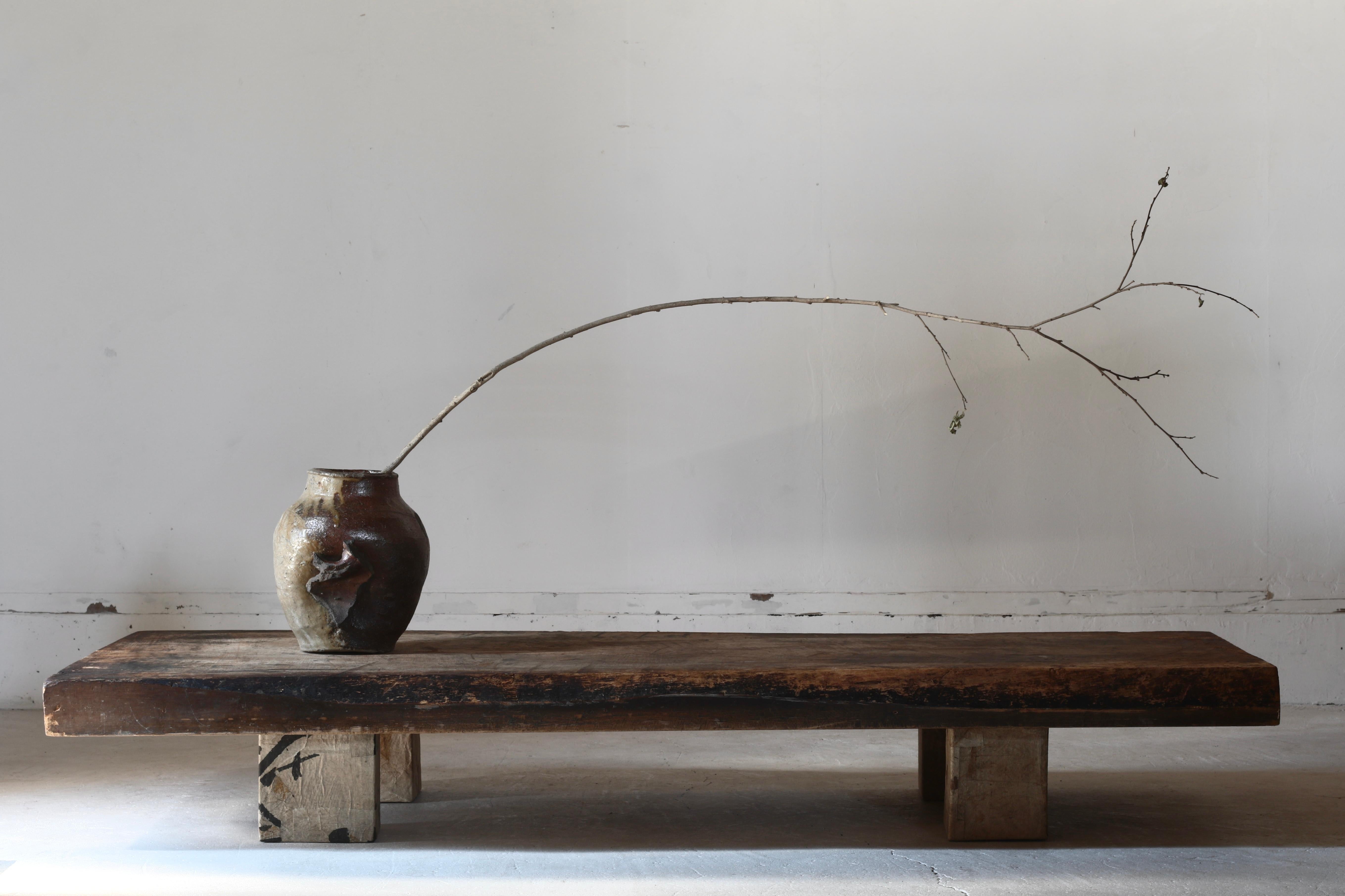 This is a large low table made from old Japanese wood.

The tabletop is a very large, heavy board. Over the years, the surface has changed to a natural, primitive look. Its use is unknown, but it is assumed to have been a work board for cutting