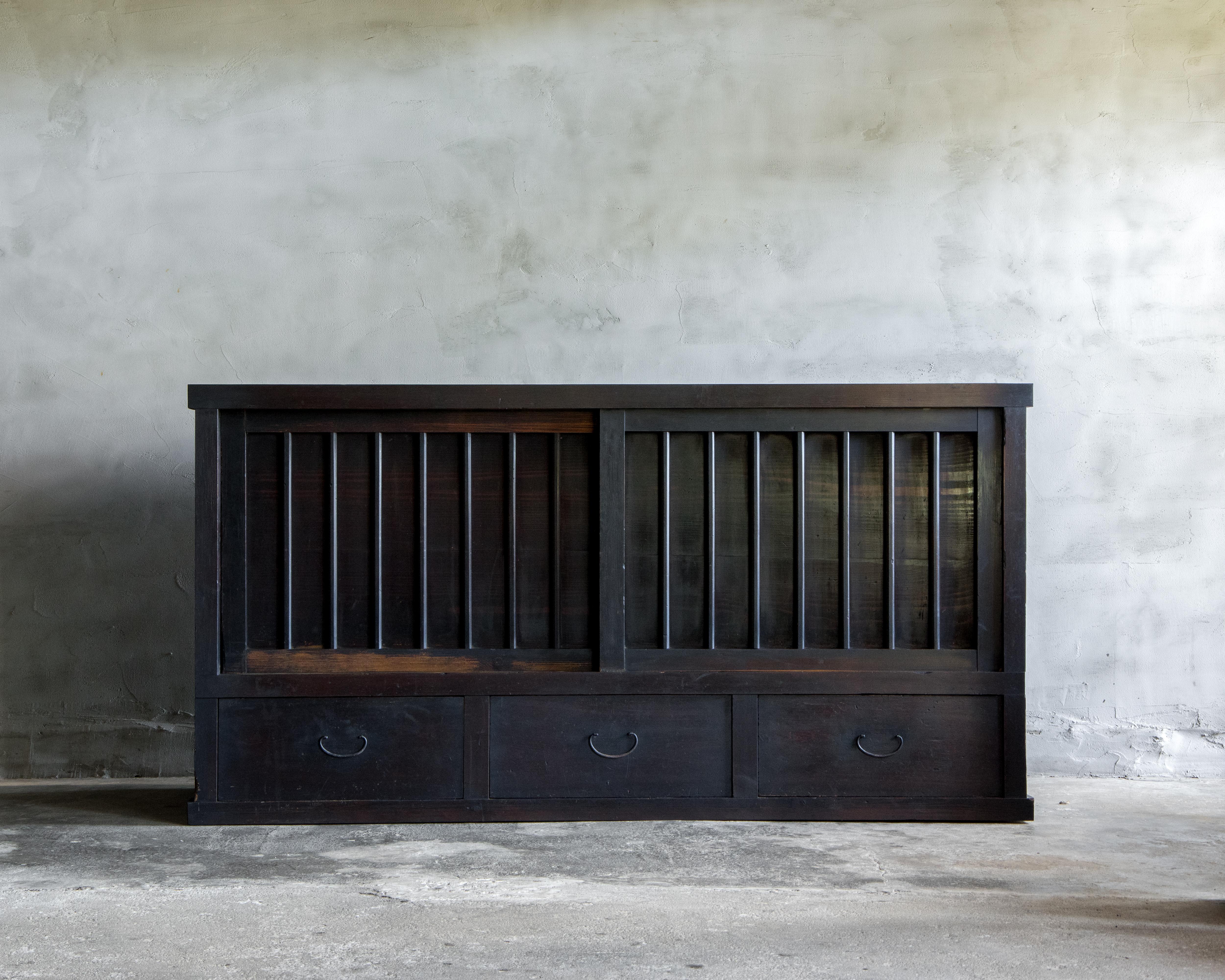 Ce grand tansu antique de Mizuya a été fabriqué à l'époque Meiji (1868-1912).

Finie avec la laque japonaise traditionnelle urushi, la surface s'est approfondie jusqu'à atteindre un noir riche au fil du temps, mettant en valeur une belle patine qui