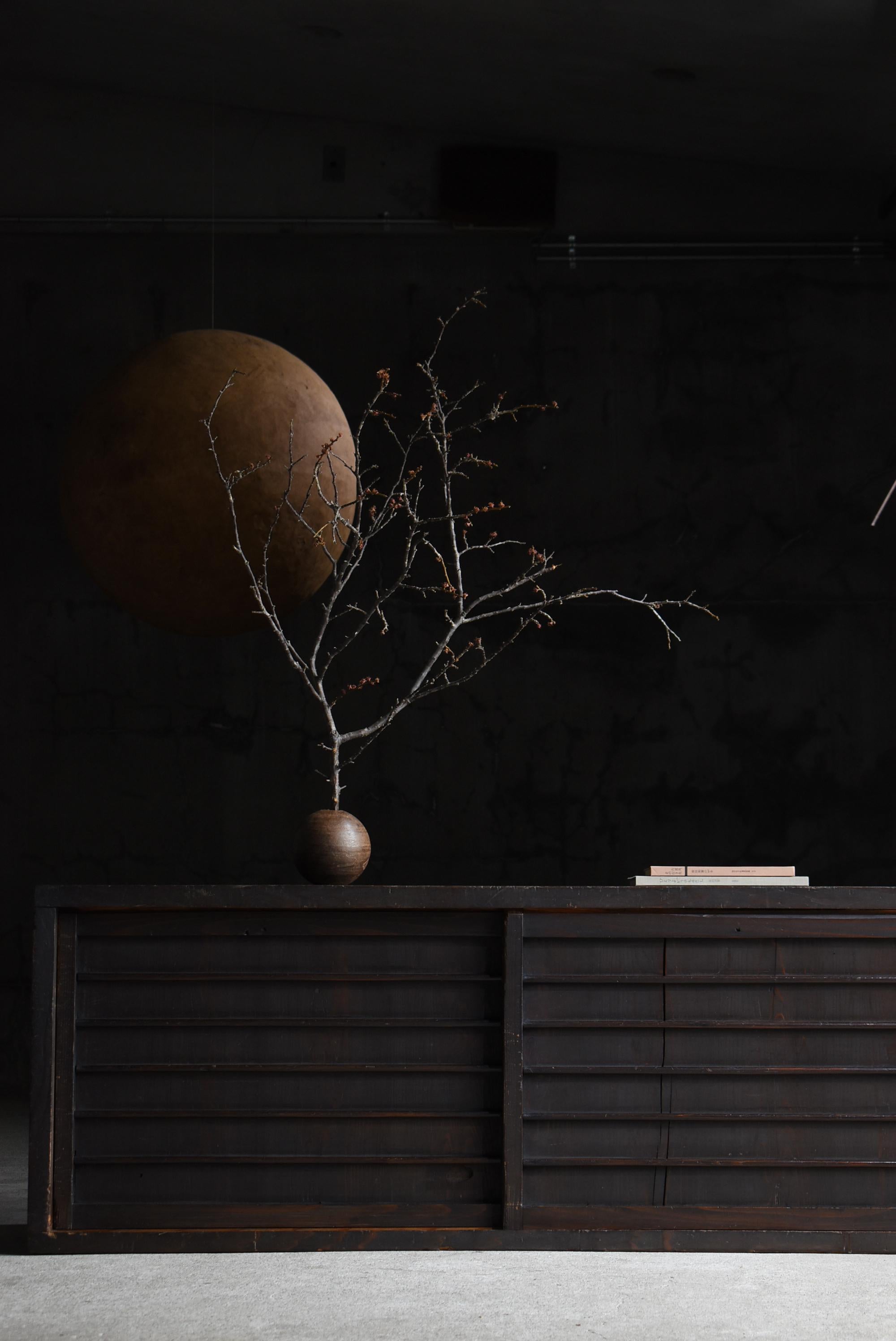 Se trata de un gran arcón Tansu japonés antiguo, fabricado durante el periodo Meiji (1860-1900). Está hecho de madera de cedro, conocida por sus cualidades ligeras pero duraderas.
El diseño es extraordinariamente sencillo, caracterizado por líneas