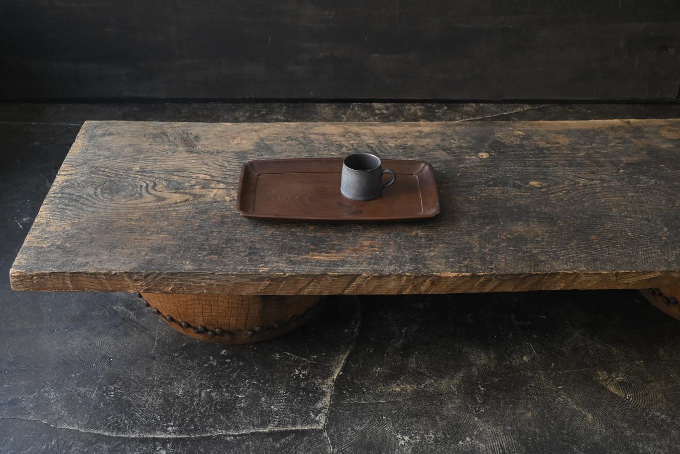 Dies ist ein ganz besonderer niedriger Tisch, der ein altes japanisches großes Brett mit einem Tischfuß aus wiederverwendeten traditionellen japanischen Trommeln kombiniert.

Die Deckplatte ist aus Zedernholz aus der Taisho- und frühen Showa-Periode