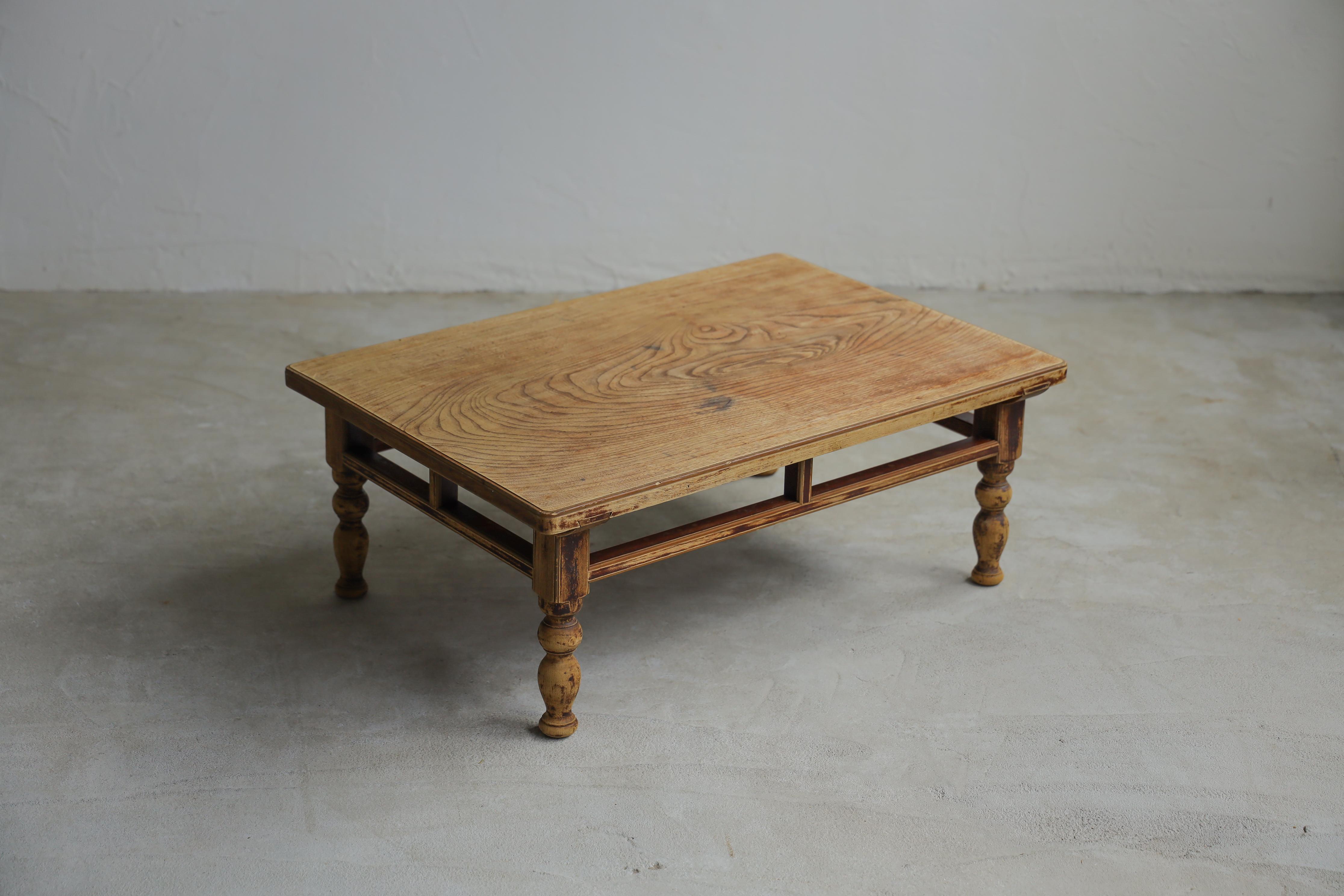 Dieser antike niedrige Tisch stammt aus der Taisho-Zeit.

Die Tischplatte ist aus einem einzigen Stück hochwertigen Zelkova-Holzes gefertigt. Die Beine sind gedrechselt.

Er ist mit einer Ginkgo-Oberfläche versehen, die die Ecken abrundet. Die