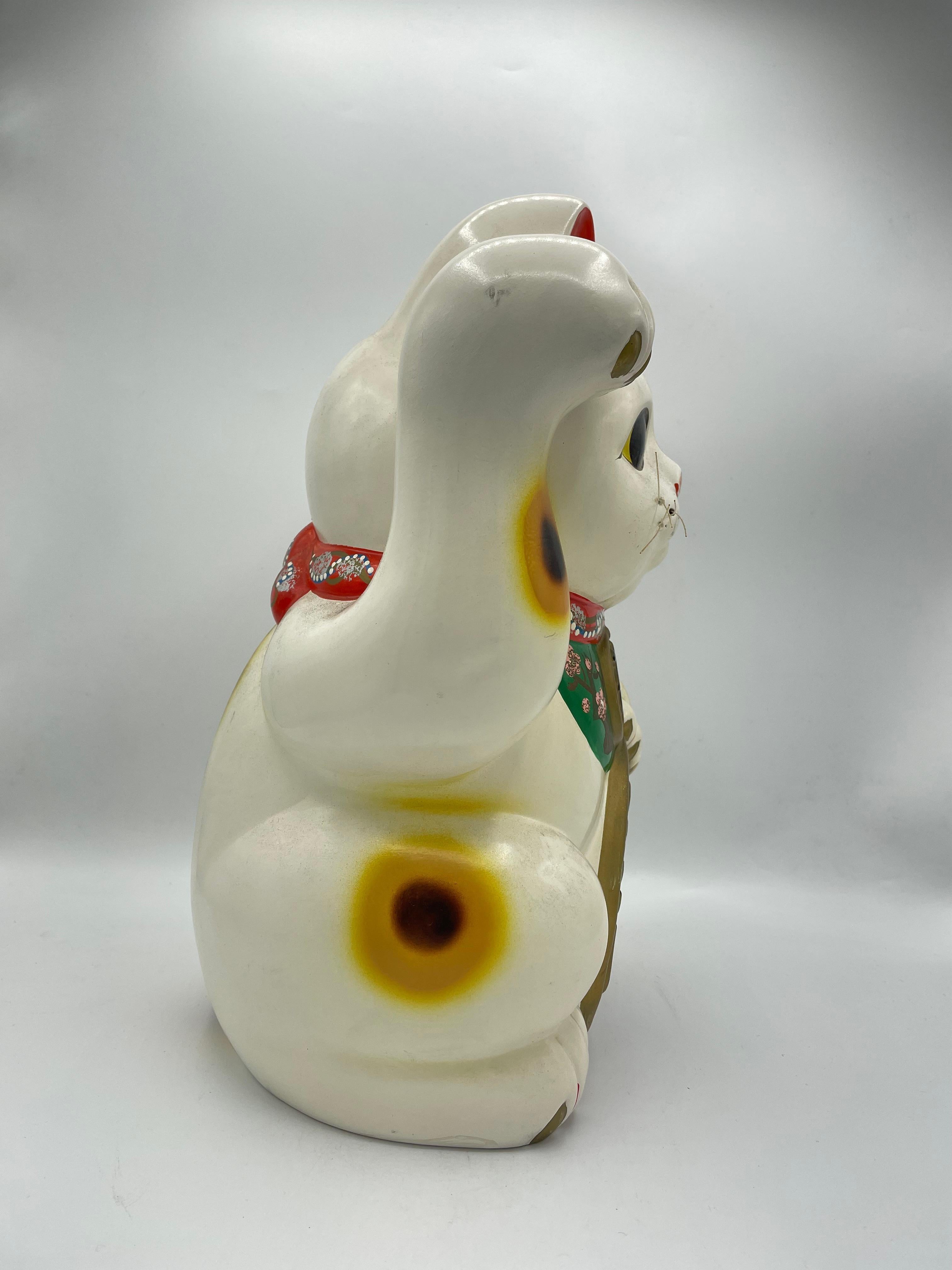 This is a vintage piggy bank of manekineko cat. It is made with Pottery and it was made around 1960s in Showa era.

The maneki-neko is a common Japanese figurine which is often believed to bring good luck to the owner. In modern times, they are