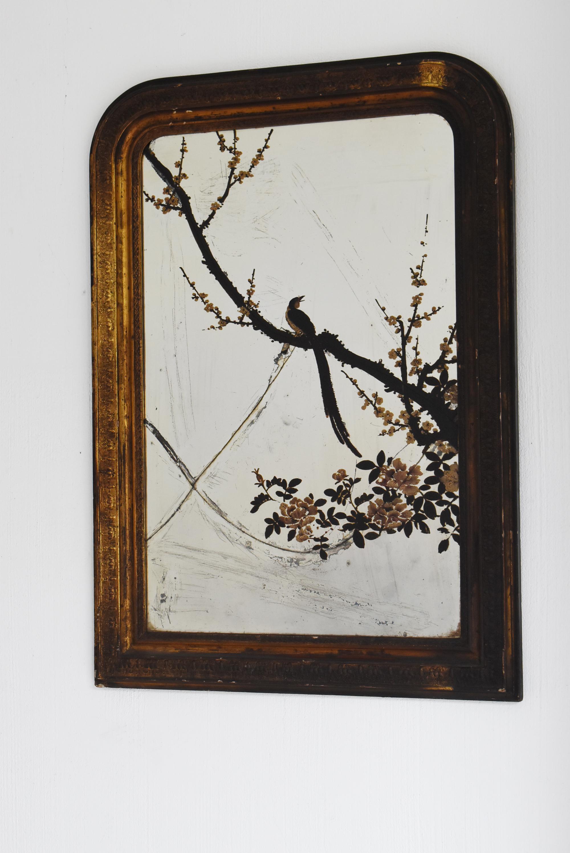 This is an old Japanese mirror crafted during the Meiji period (1860s–1900s). Despite the passage of time, it retains a quiet and graceful beauty. The mirror surface bears visible cracks that tell the story of its age; yet, rather than viewing them