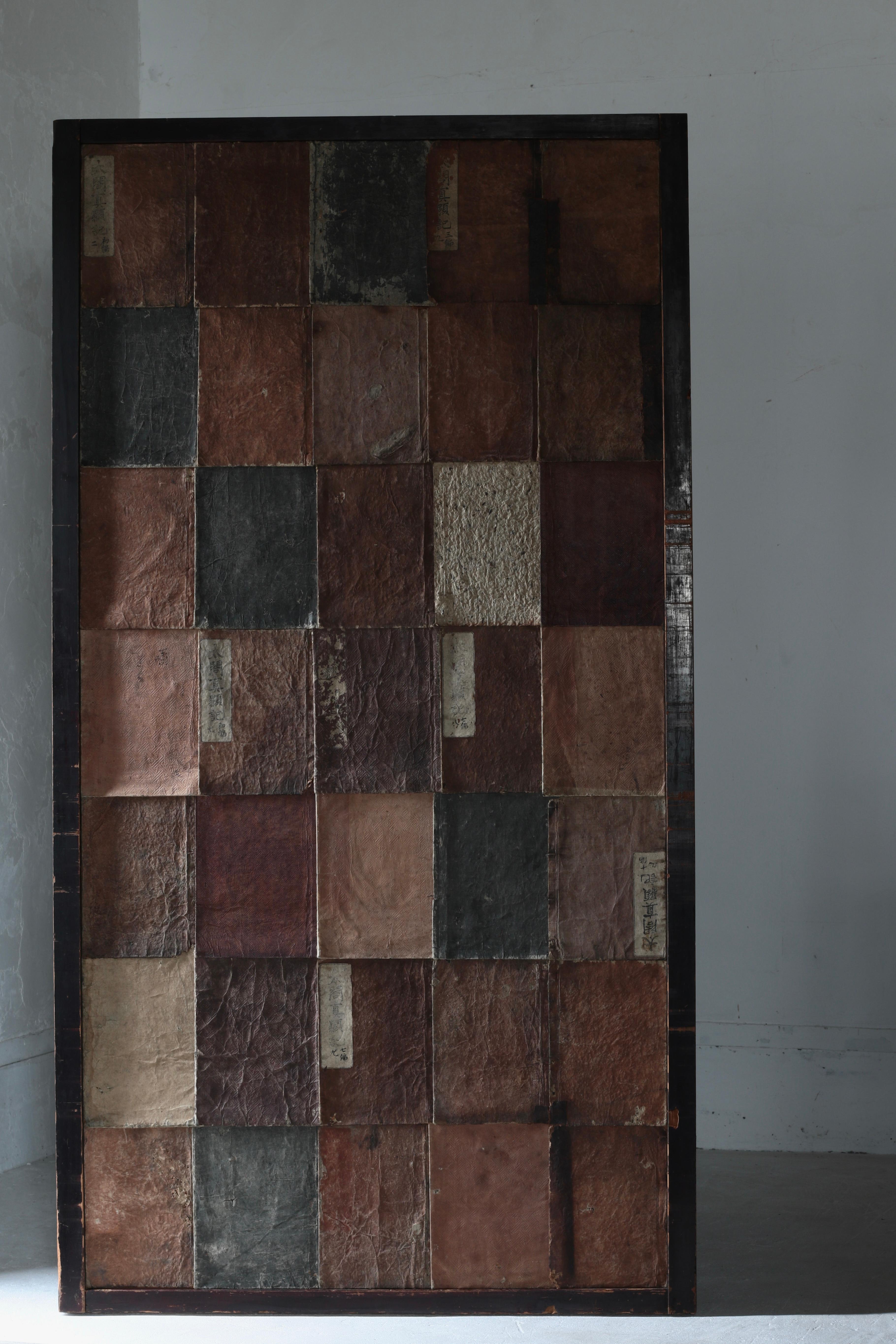 This is an original wall decoration made by combining Japanese antiques.

The paper with the richest variety of covers of old books from around the Meiji period is used and pasted together randomly.

The book covers of the same color have