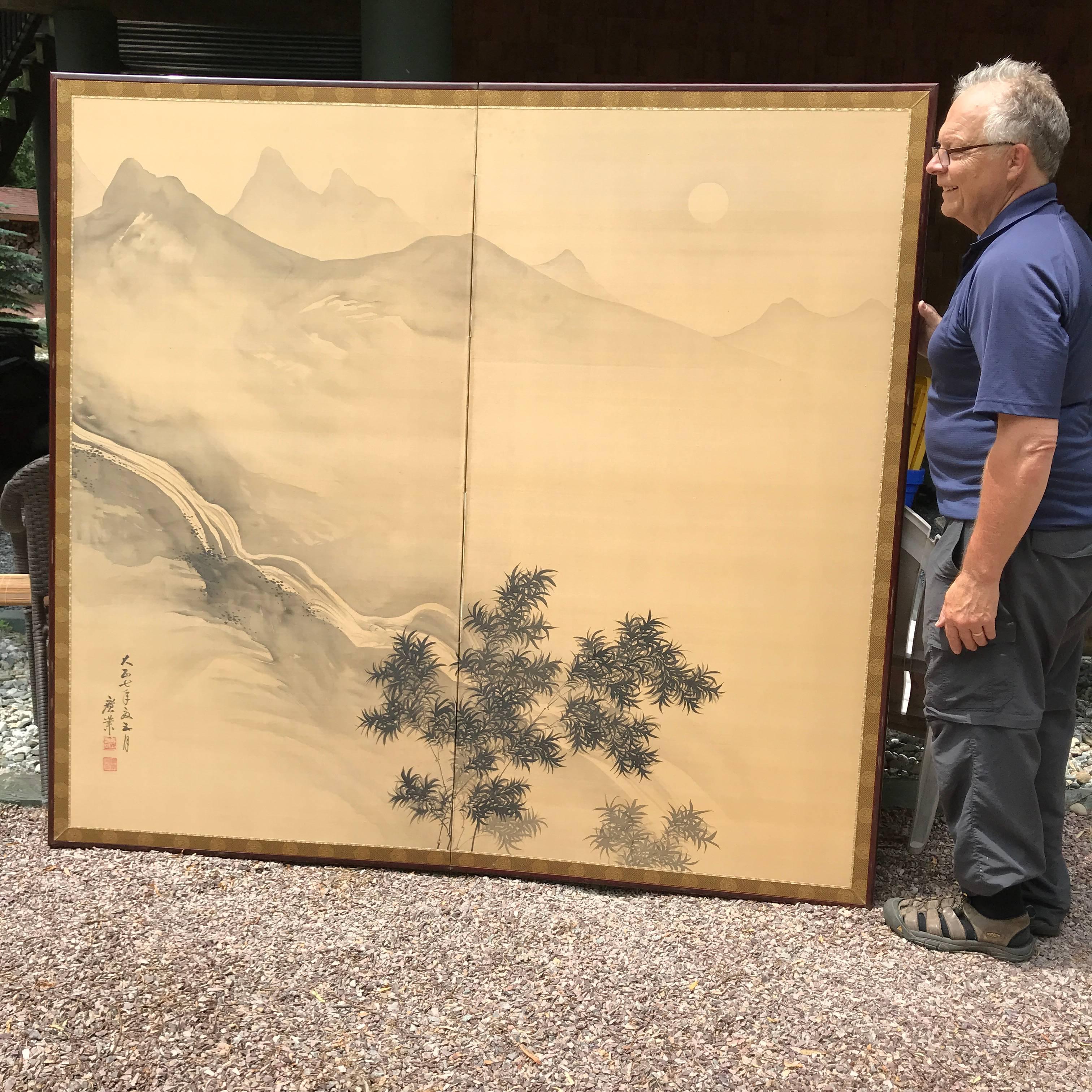 Japan, a fine two-panel screen Byobu of simple brush strokes on cream ground paper, in a serene, peaceful mood of a rising moon over mountains a waterfall and bamboo. 

It dates Taisho 7 (1918) 

It is signed Kougyou.

Enticing and unusual