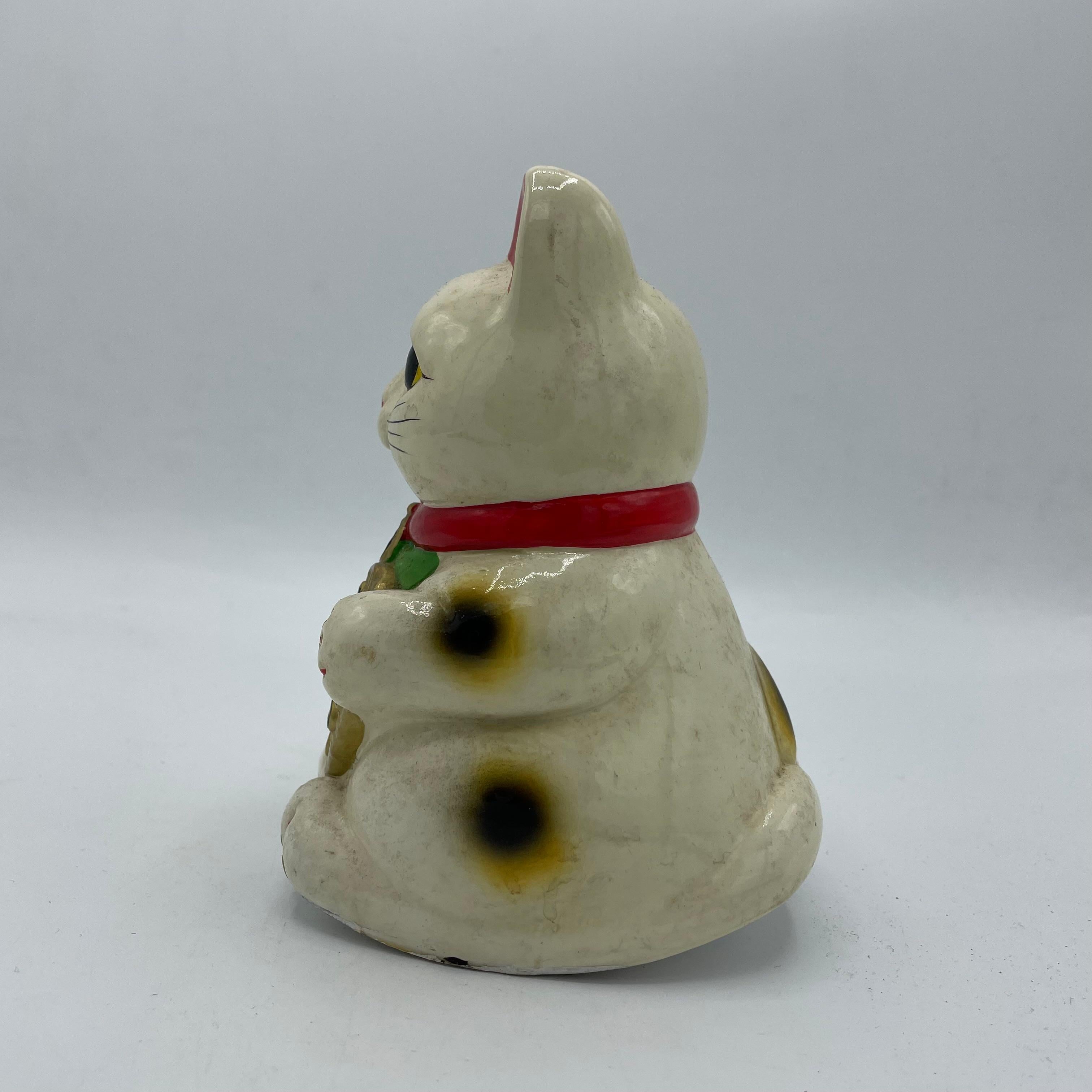 This is a vintage piggy bank of manekineko cat. It is made with pottery and it was made around 1970s in Showa era. This cat is rocking object, it is rare than the other manekineko cat.

Dimensions. 
10 x 8.5 x H14 cm 

The maneki-neko is a common