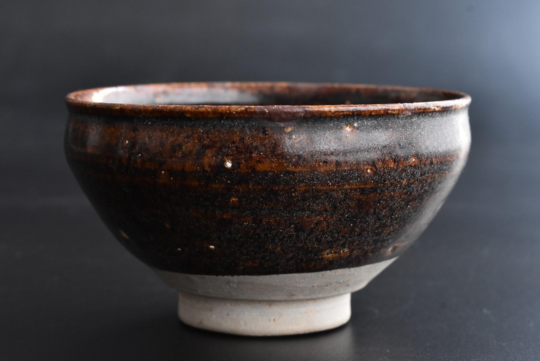 A Mino ware bowl made in Japan from the old Momoyama period to the early Edo period (1573-1650).
Mino ware produced many tea utensils.
Reference materials for art books are posted.

It is baked with a dark brown glaze.
It is a glaze that