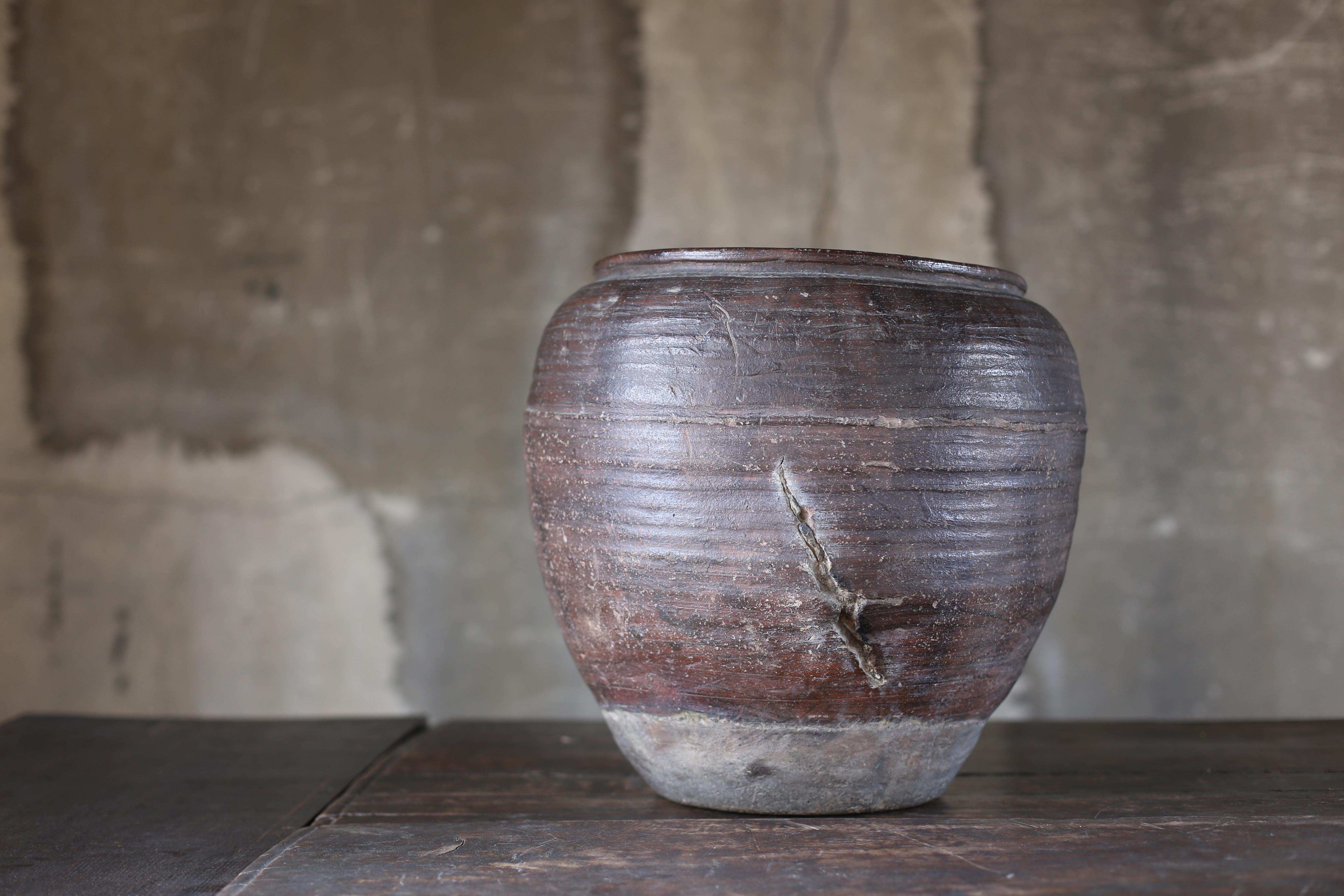 It is an old jar baked in Japan.
It seems to be in the Edo period (1700s-1800s).

The unique distorted shape is beautiful.
The color and balance of the glaze are also exquisite and wonderful.
It has two beautiful ripped.They make us feel