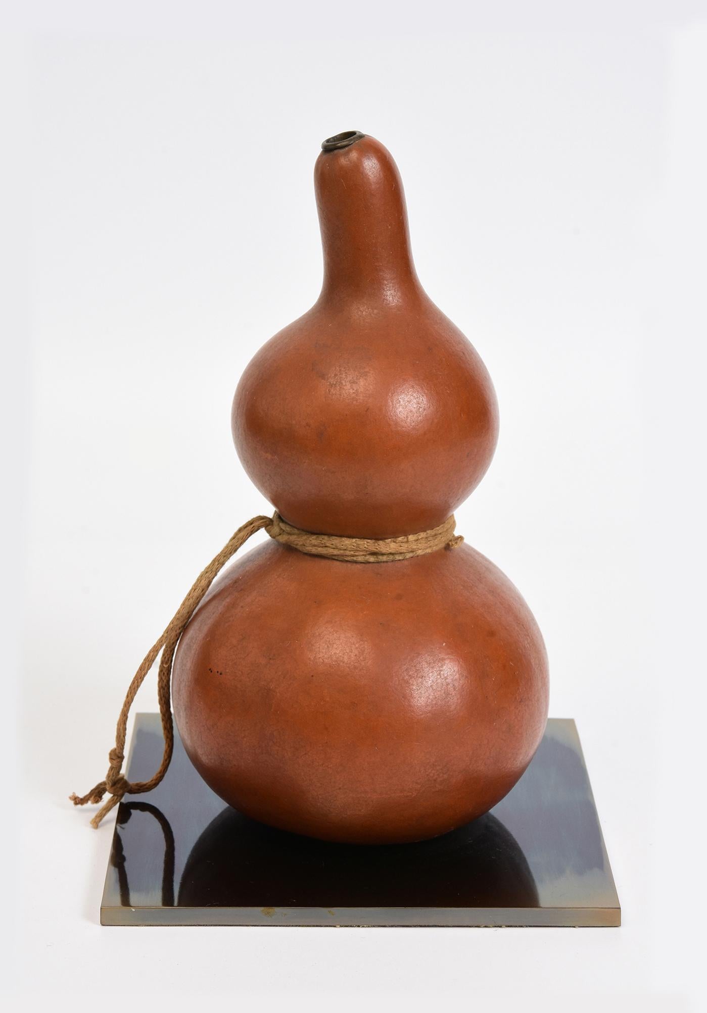 Vase à boire samouraï ancien en excellent état, laqué rouge et muni d'un bouchon en bois. Les glands en corde faits à la main complètent l'ensemble.

La patine foncée due à son âge rehausse sa beauté historique.  La gourde à saké était un attribut