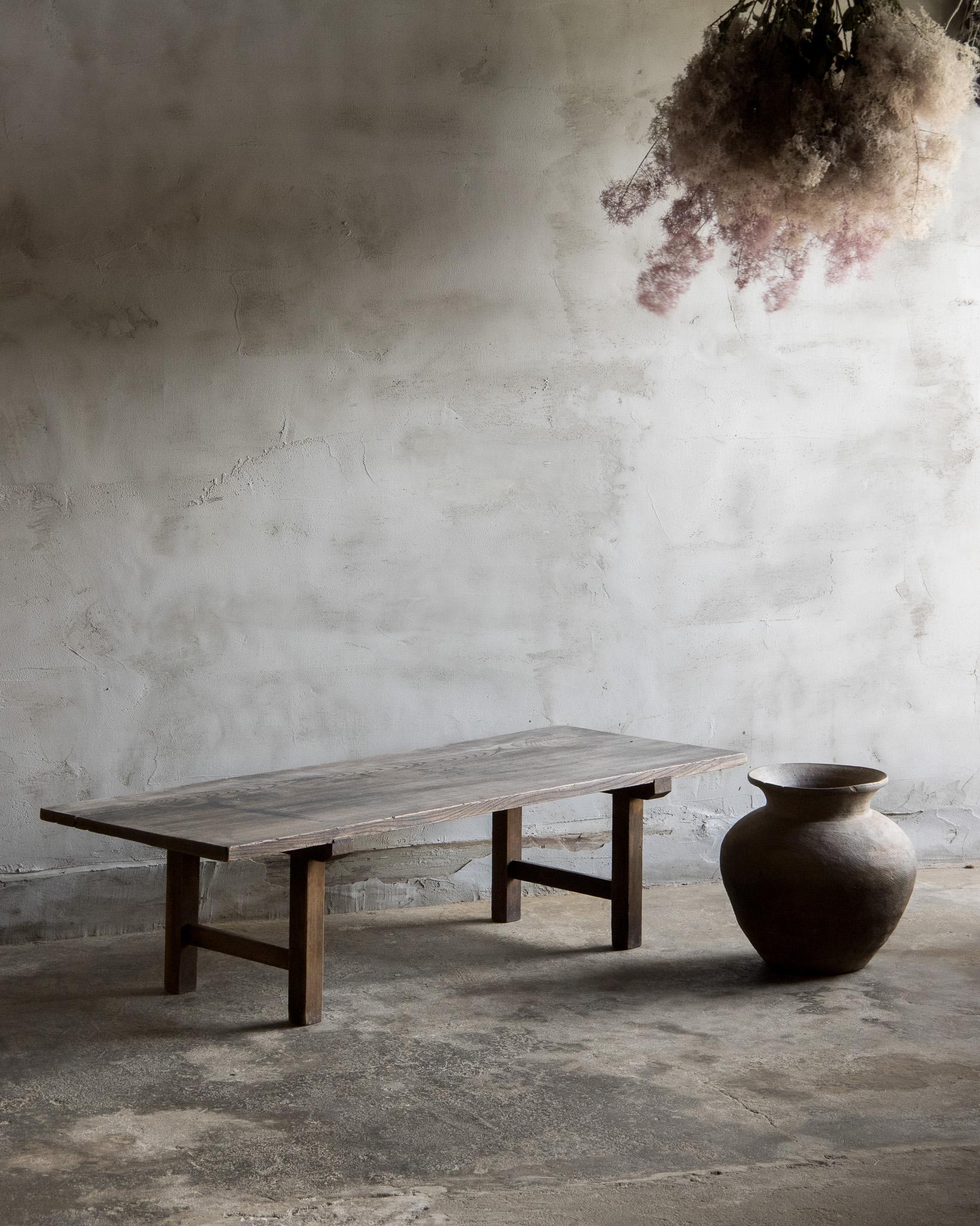 This antique side table was crafted in the Late Meiji Era (1868–1912).
The top is made from solid zelkova (keyaki) wood, paired with legs crafted from cedar. The surface has developed a soft, uneven coloration over time—subtle areas of fading and