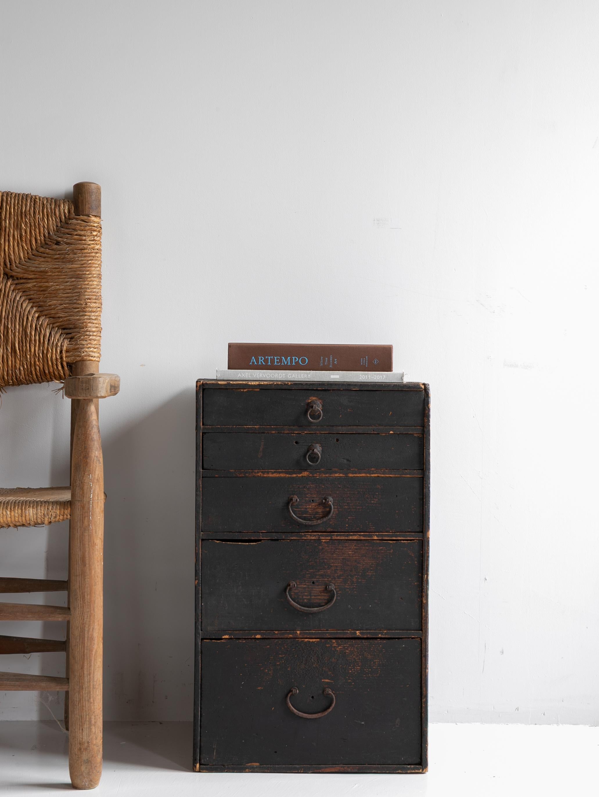 This is an antique Japanese small chest of drawers (小引出し) crafted in the Meiji period (late 19th to early 20th century).
The piece features a deep black lacquered surface that has developed a rich patina over time, softly revealing the natural grain