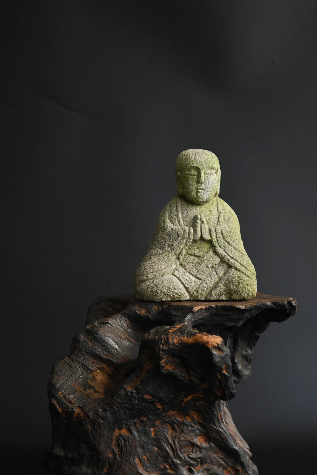 Si tratta di una piccola statua di Buddha in pietra creata in Giappone tra la fine del periodo Edo e il periodo Taisho. Scolpita in una solida pietra simile al granito, conserva l'immagine delle mani del Buddha giunte in preghiera, le pieghe della