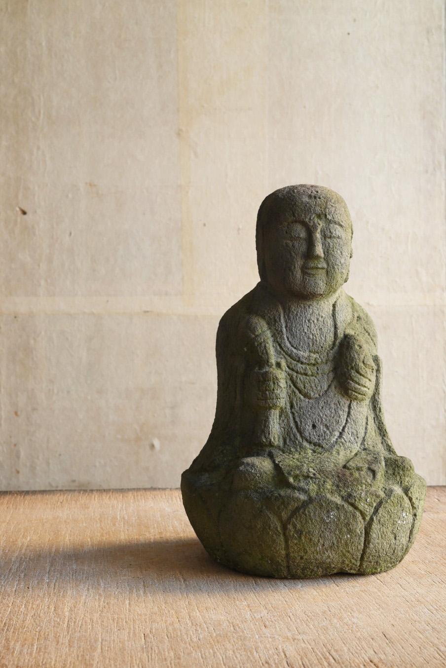 This is a stone Buddha from the Edo period (1750-1850) made of andesite.
It is Jizo Bodhisattva with a lotus flower (or a staff) in his right hand and a jewel in his left hand.
Jizo is one of the Bodhisattvas in the world of Buddhism.
It is a being