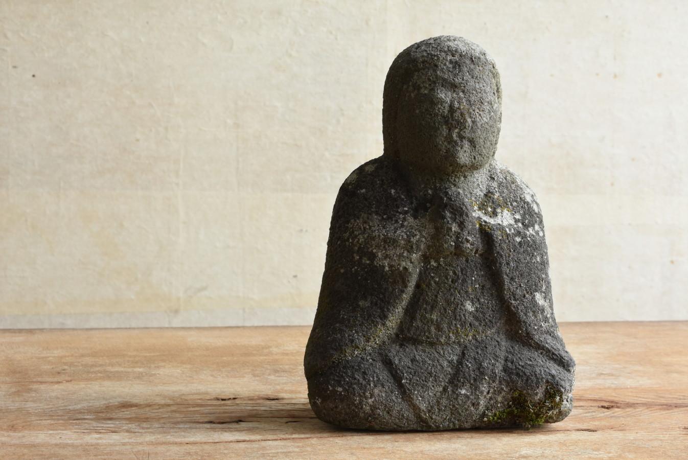 It is a Japanese Edo period (1800s) stone Buddha statue made of andesite.
This Buddha statue has folded hands and is probably a bodhisattva.
Bodhisattvas are benevolent beings who save people.
He is dressed like a monk and stands still with his