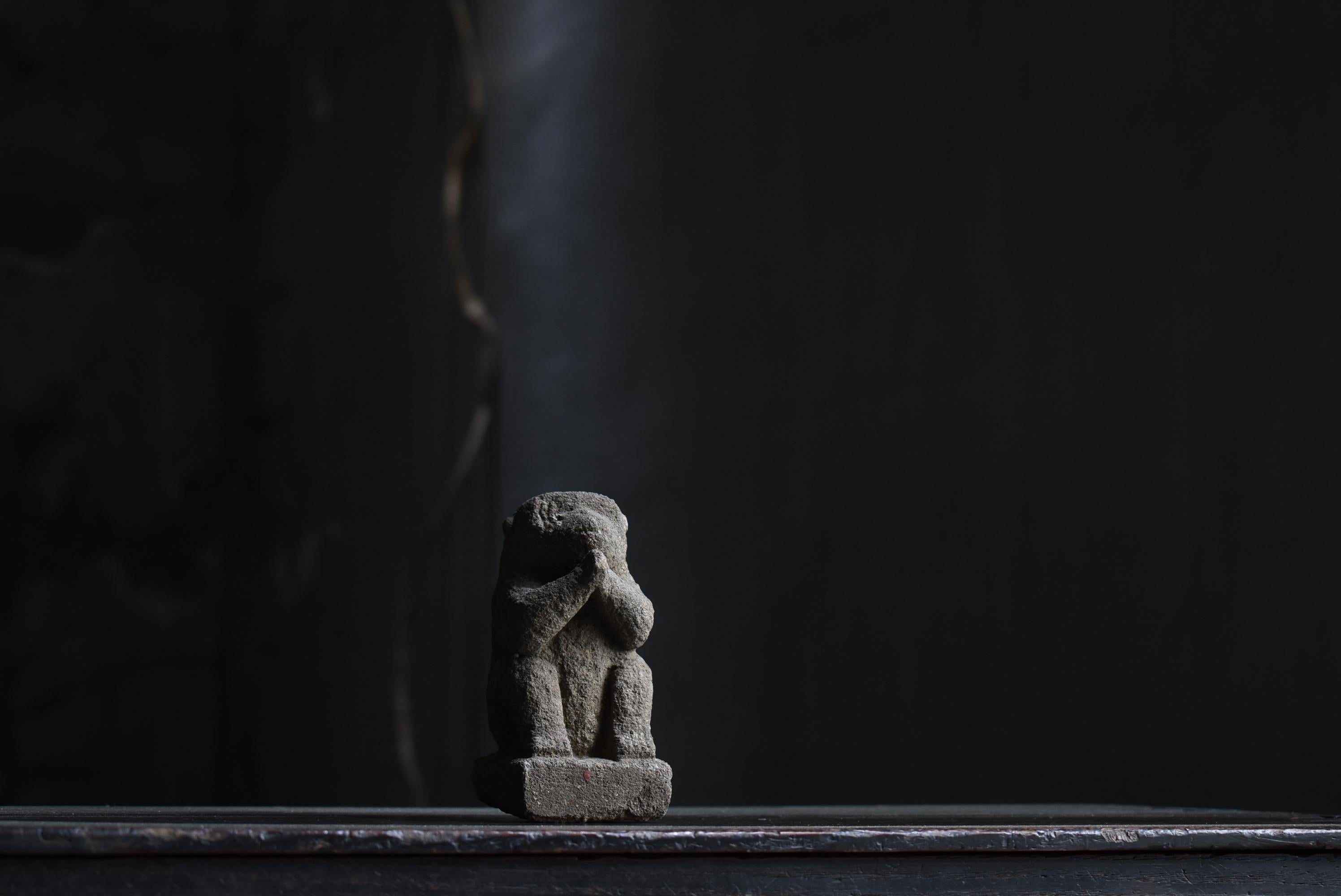 This is a very old Japanese stone carved monkey.
It was made during the Edo period (1800s-1860s).
It appears to be carved of a monkey praying.
It has been cherished as a good-luck charm.

The expression on the monkey's face seems to be