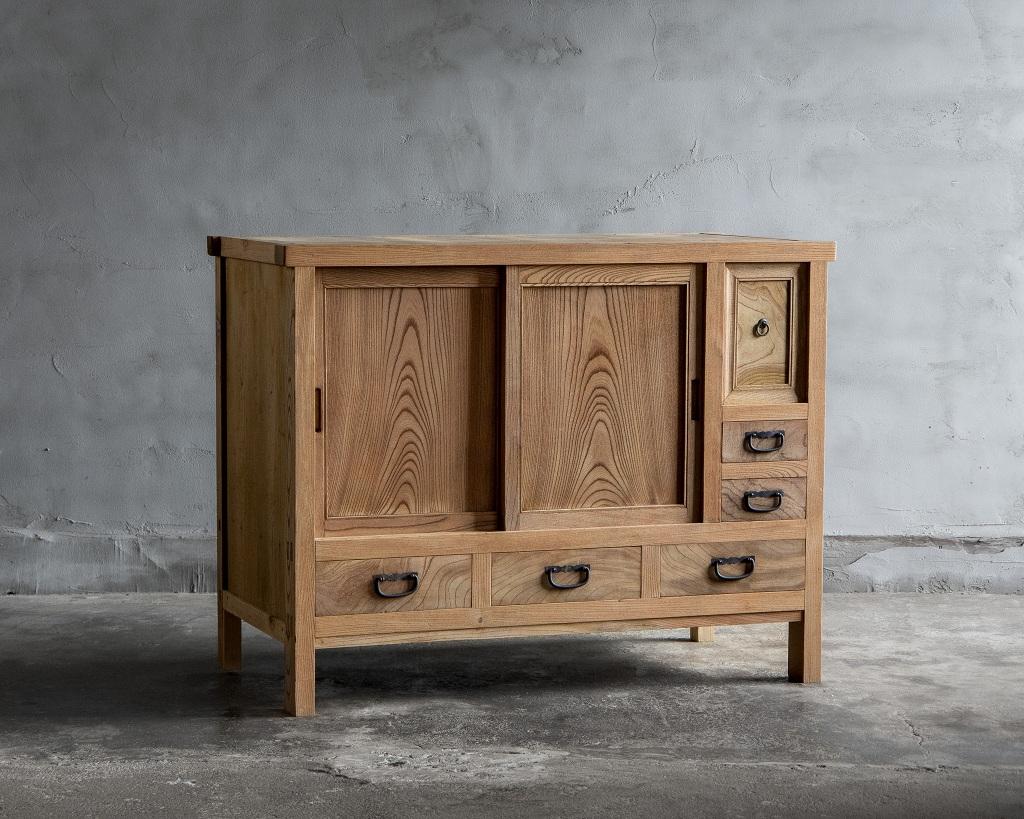 This Japanese antique storage cabinet was crafted in the Taisho Era (1912–1926).

Made from zelkova wood (keyaki), this piece showcases a rich grain pattern that adds warmth and sophistication to any interior. The wood’s natural texture has aged