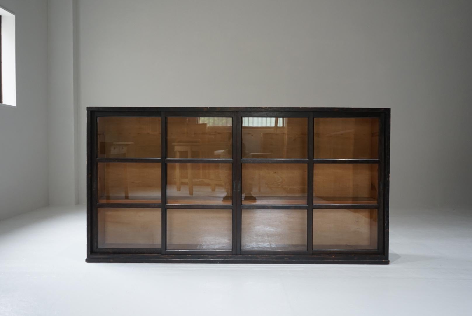 This is an old Japanese glass door storage shelf.
The deep colours create a nice atmosphere.
The shelves are sturdy and can be used as a cupboard or bookshelf.
There are four doors allowing free access inside.
There is a small gap in the center when