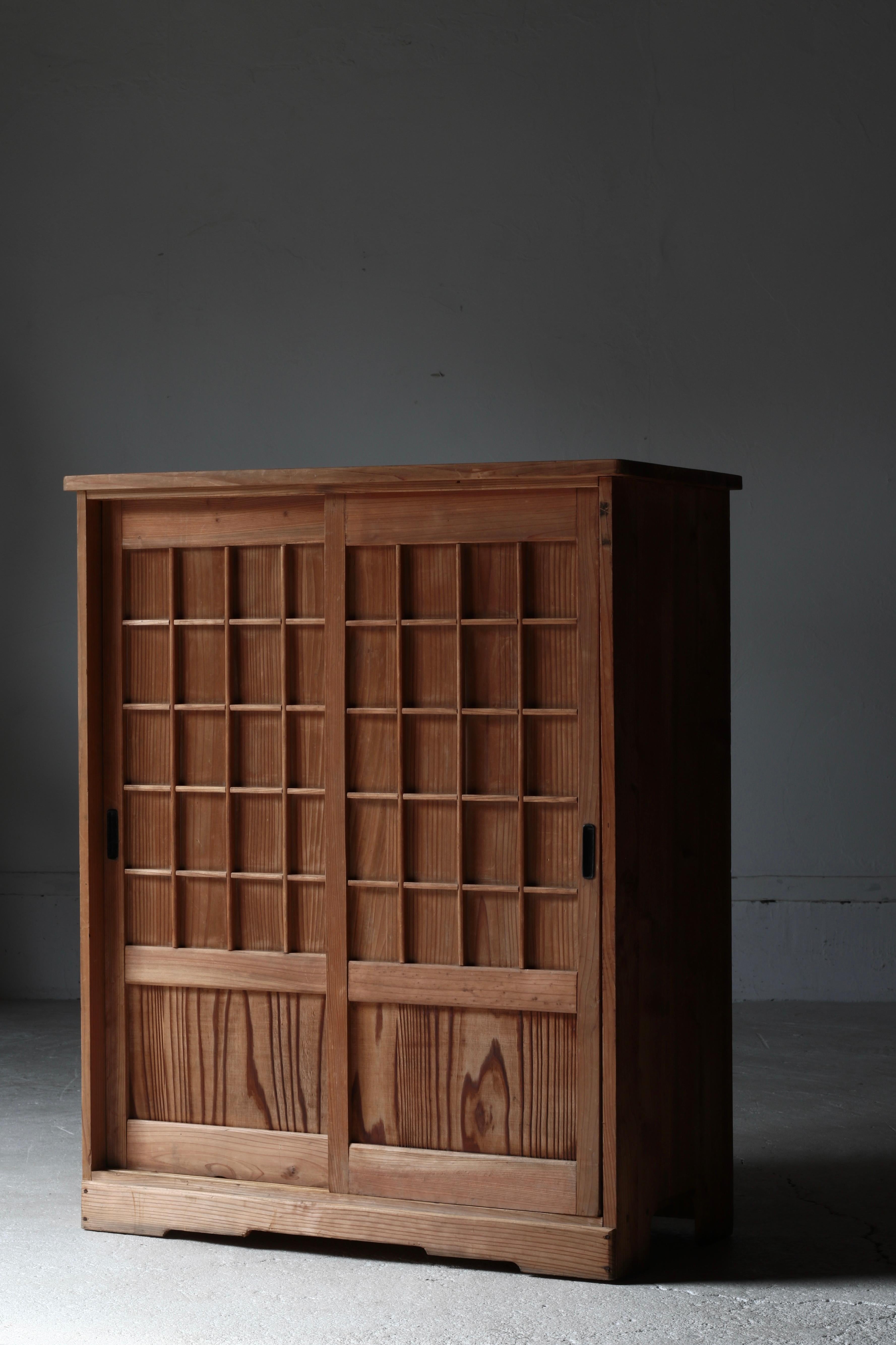 This is an old Japanese storage shelf.
It is made of cedar and is thought to have originally been used as a shoe cabinet.

The lattice design of the wooden doors is the result of the maker's meticulous craftsmanship, and is an impressive design that