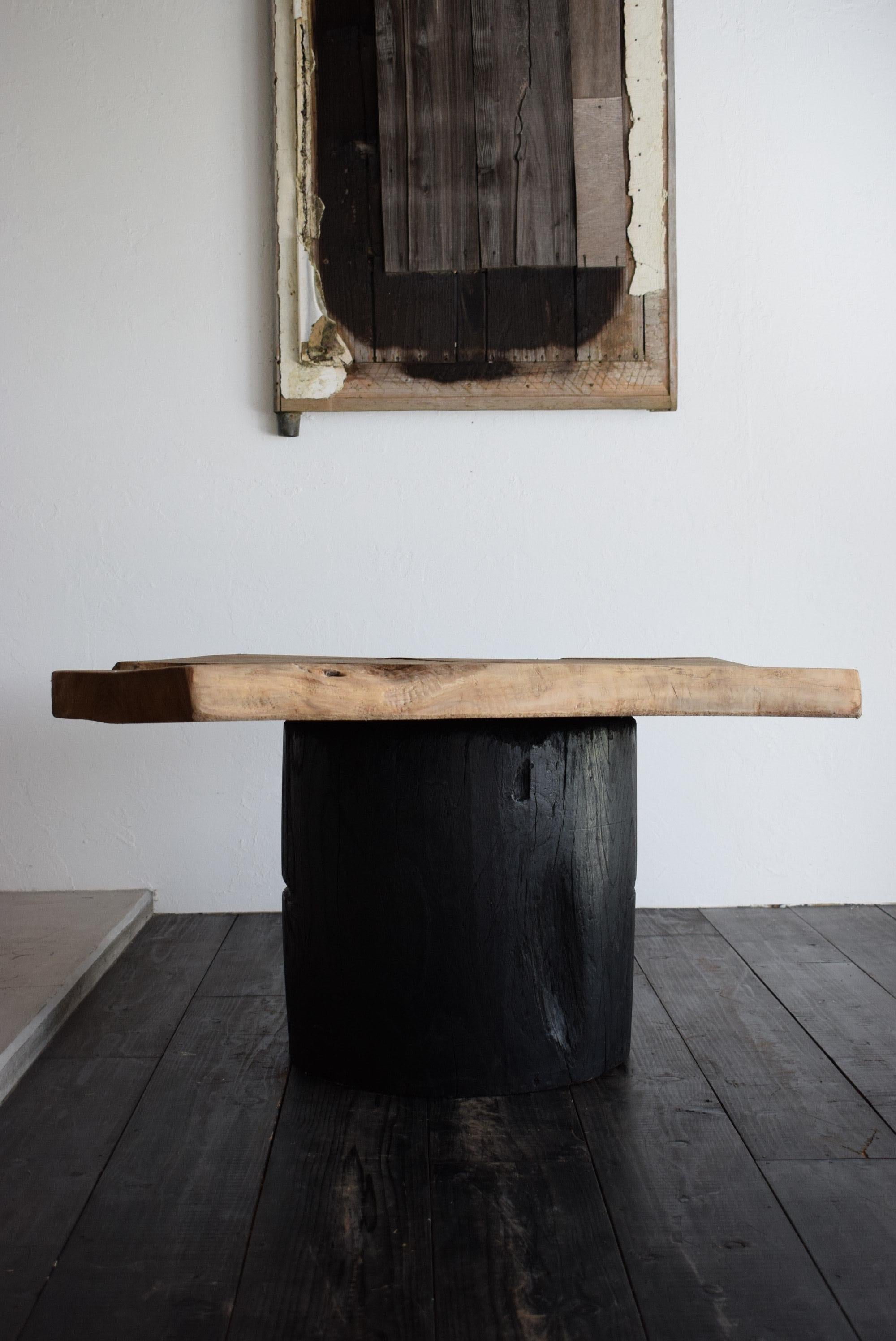 This table uses an old Japanese mortar (a container in which grains and rice cakes are pounded with a pestle and placed inside the mortar) as a base and a natural wood top.

It is a heavy and sturdy table that has a Japanese feel and gives you a